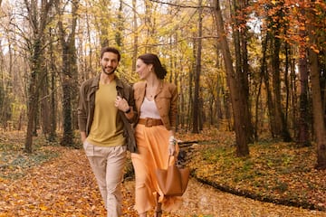 a man and woman walking in a forest