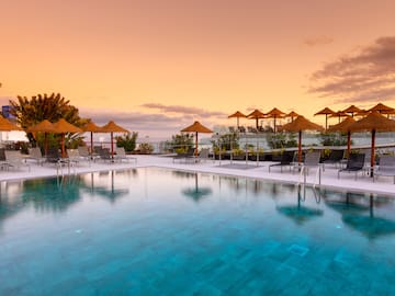 a pool with umbrellas and chairs