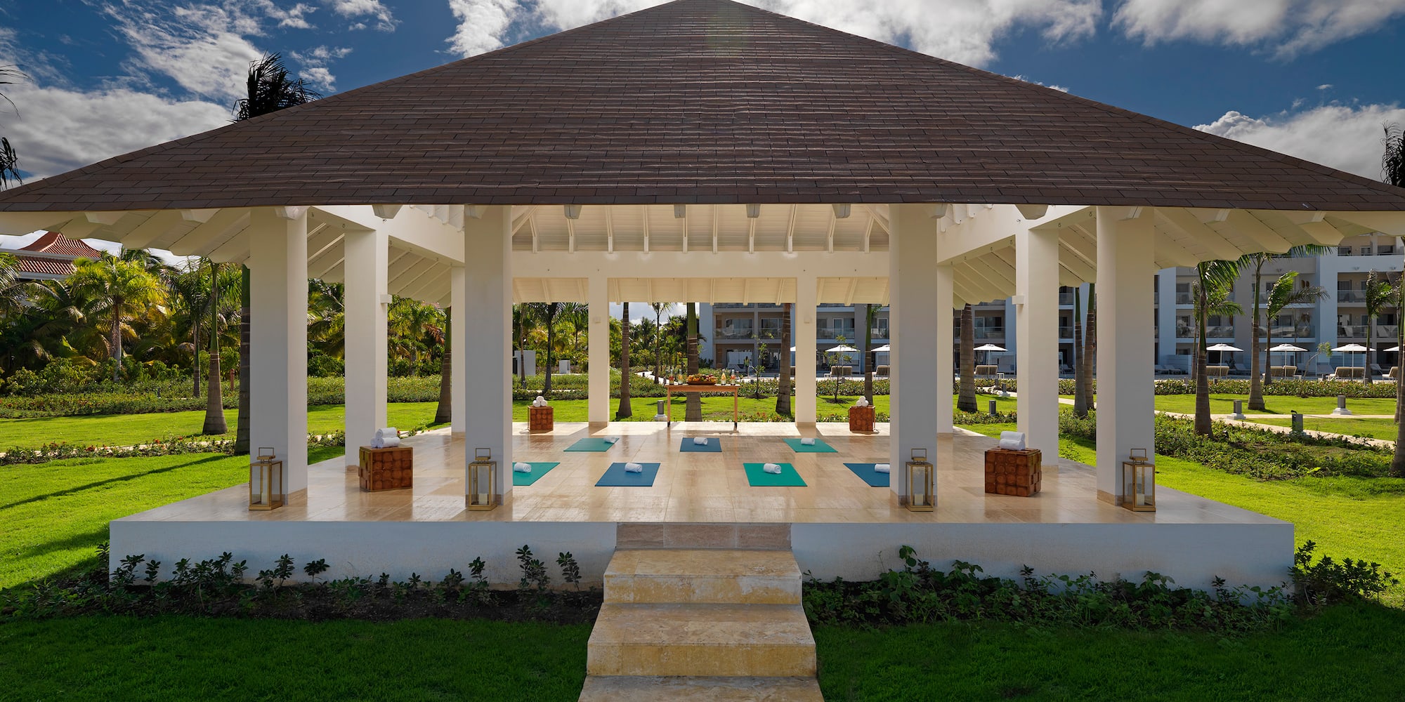 a gazebo with yoga mats and a path in a park