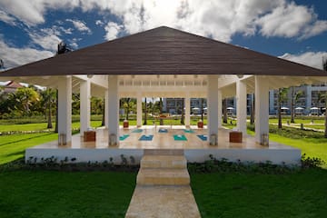 a gazebo with yoga mats and a path in a park