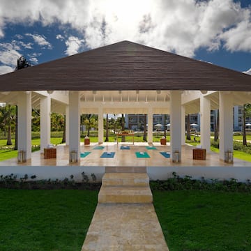 a gazebo with yoga mats and a path in a park