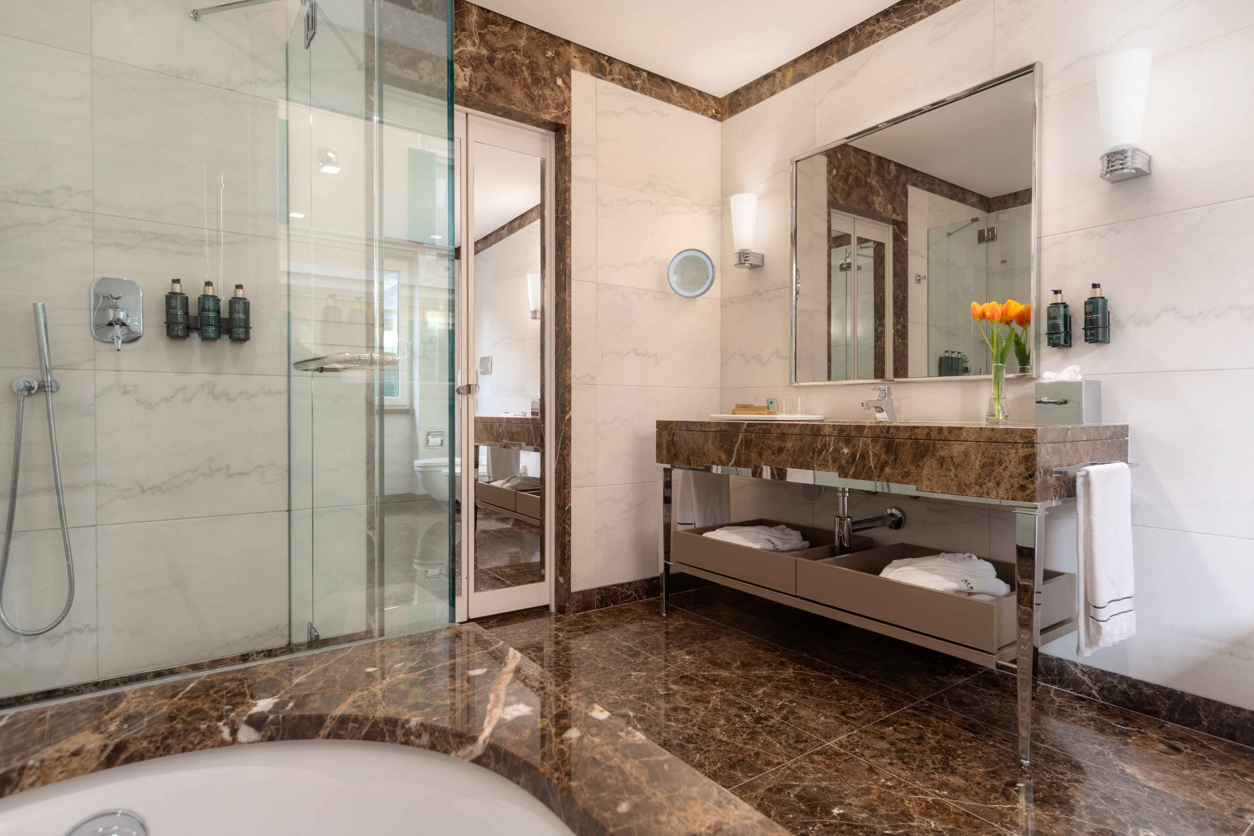 Elegant marble luxury bathroom featuring glass shower and modern vanity.