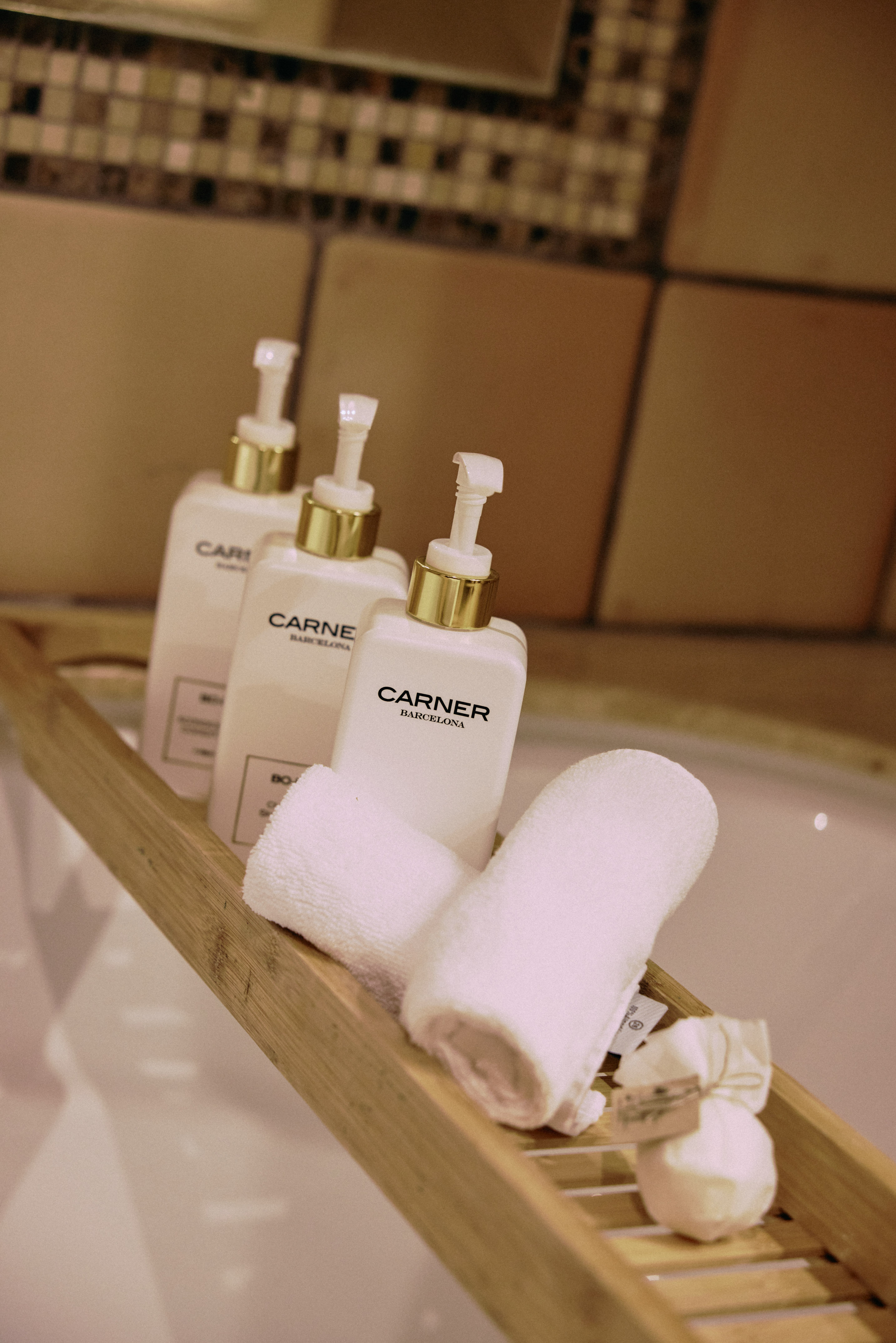 a group of white bottles and towels on a wooden shelf