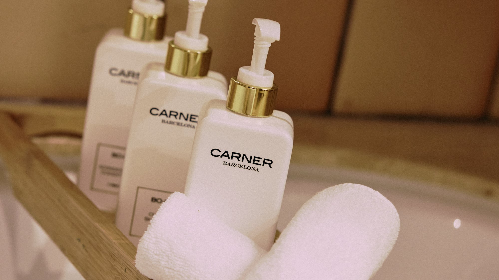 a group of white bottles and towels on a wooden shelf