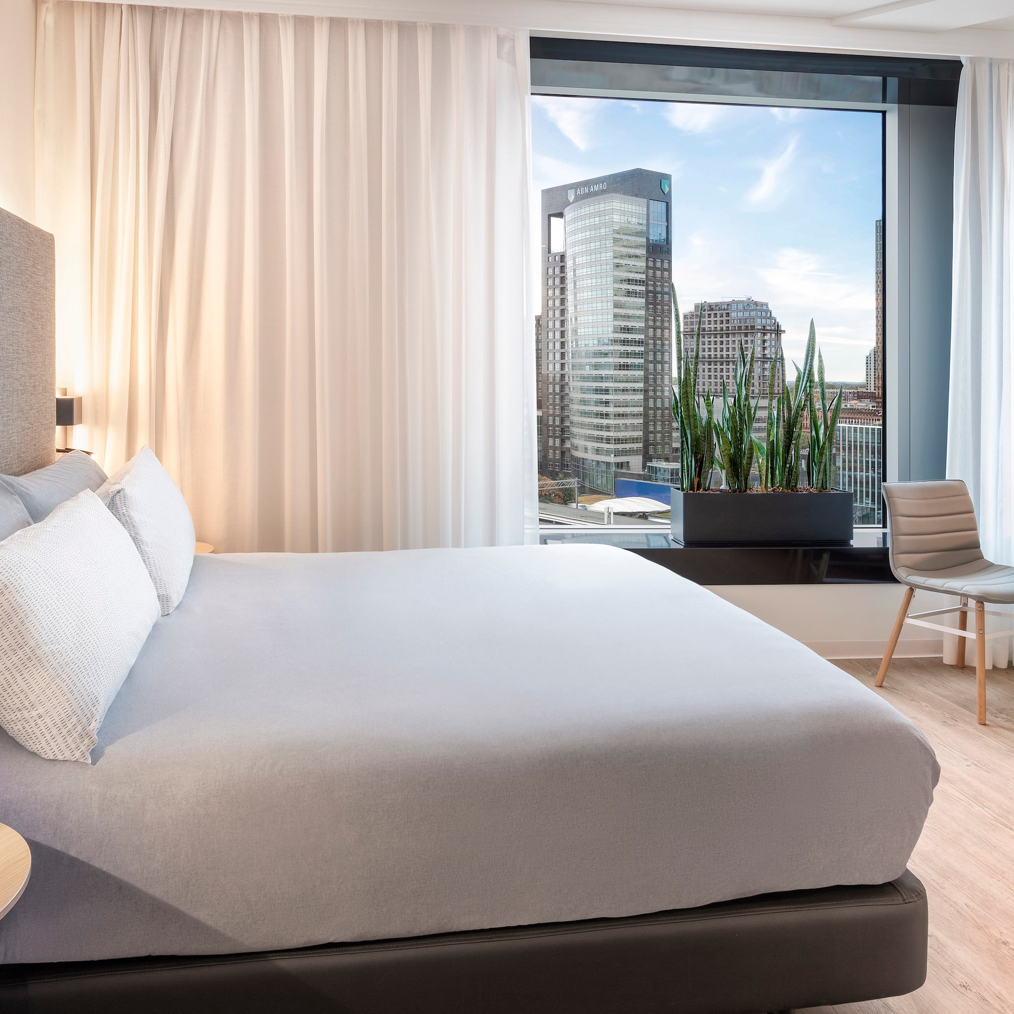 a bedroom with a large window and a bed