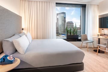 a bedroom with a large window and a bed