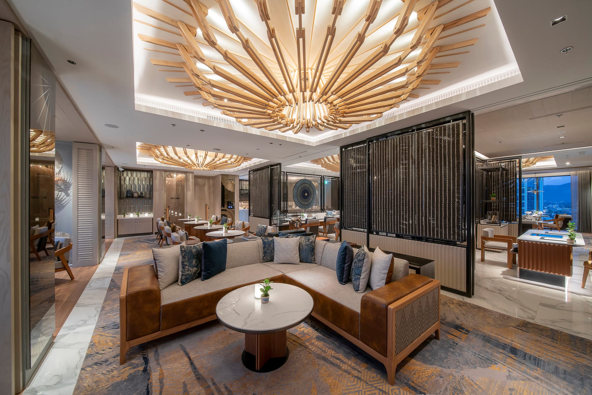 Modern hotel lounge with elegant sofa, marble table, and wooden slatted ceiling.