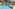 Sunny resort pool with lounge chairs, straw umbrellas, and hotel buildings.