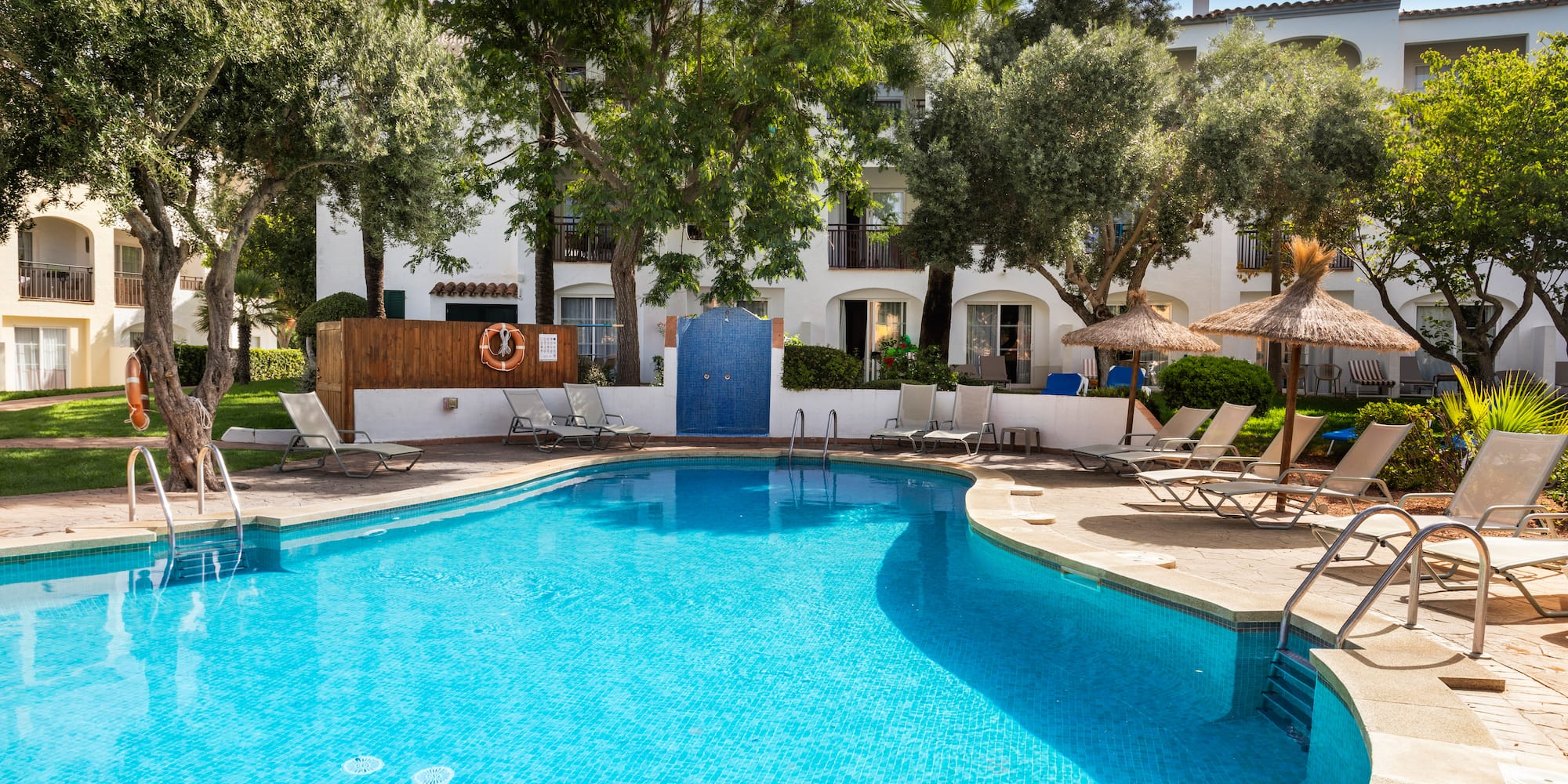 a swimming pool with chairs and umbrellas