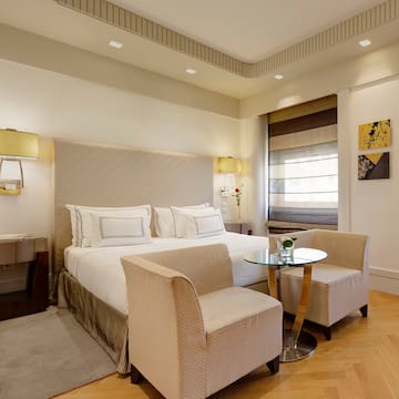 a bedroom with a bed and chairs