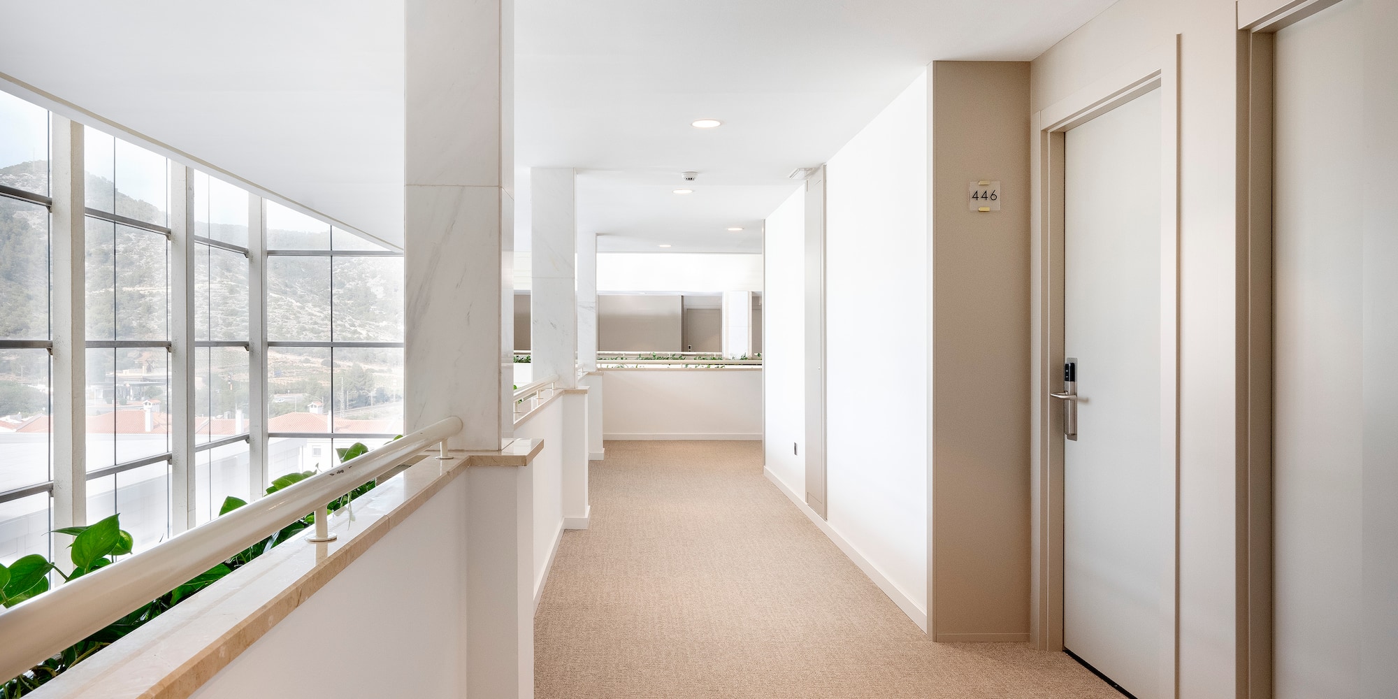 a hallway with a door and railing