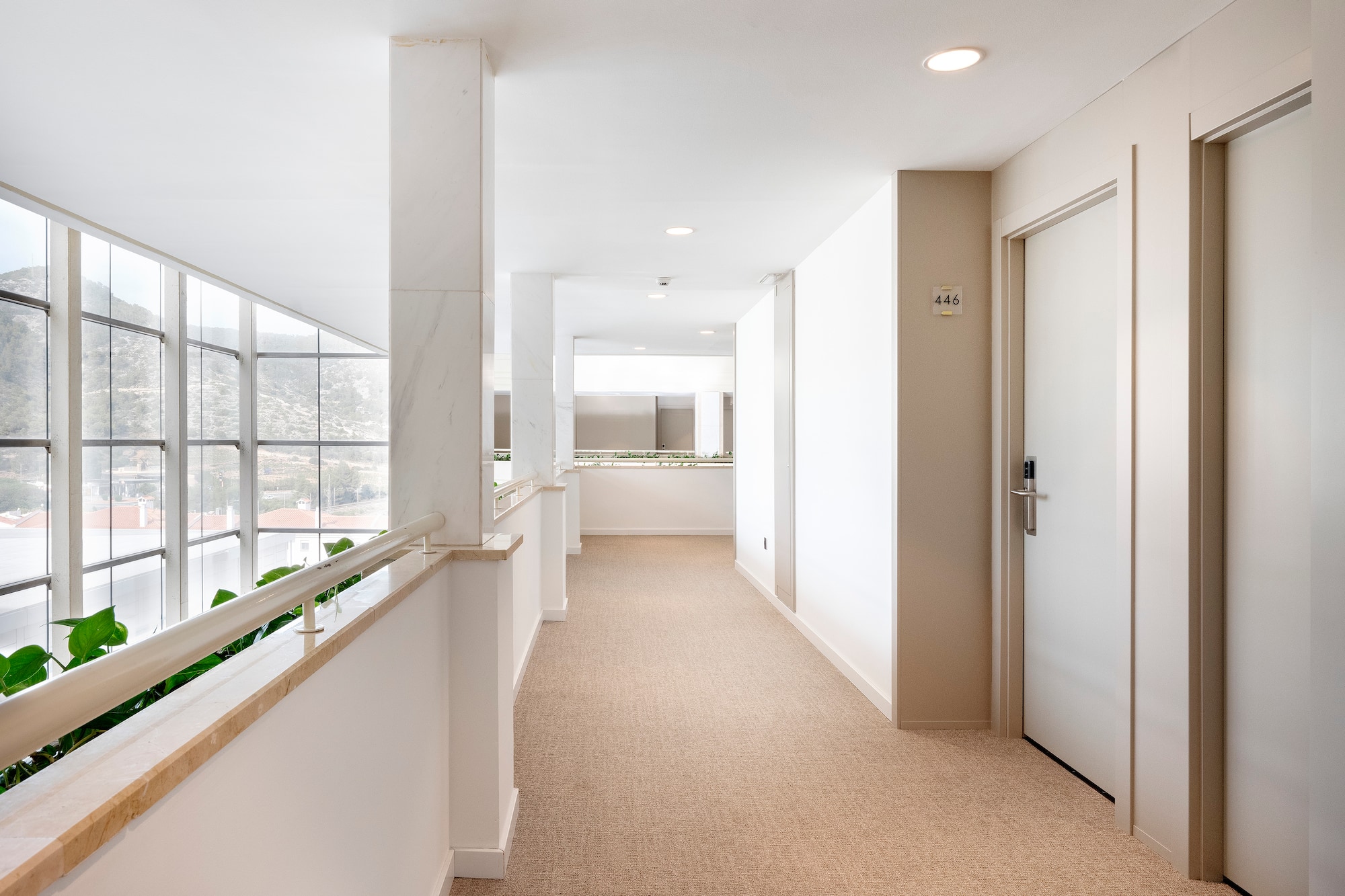 a hallway with a door and railing