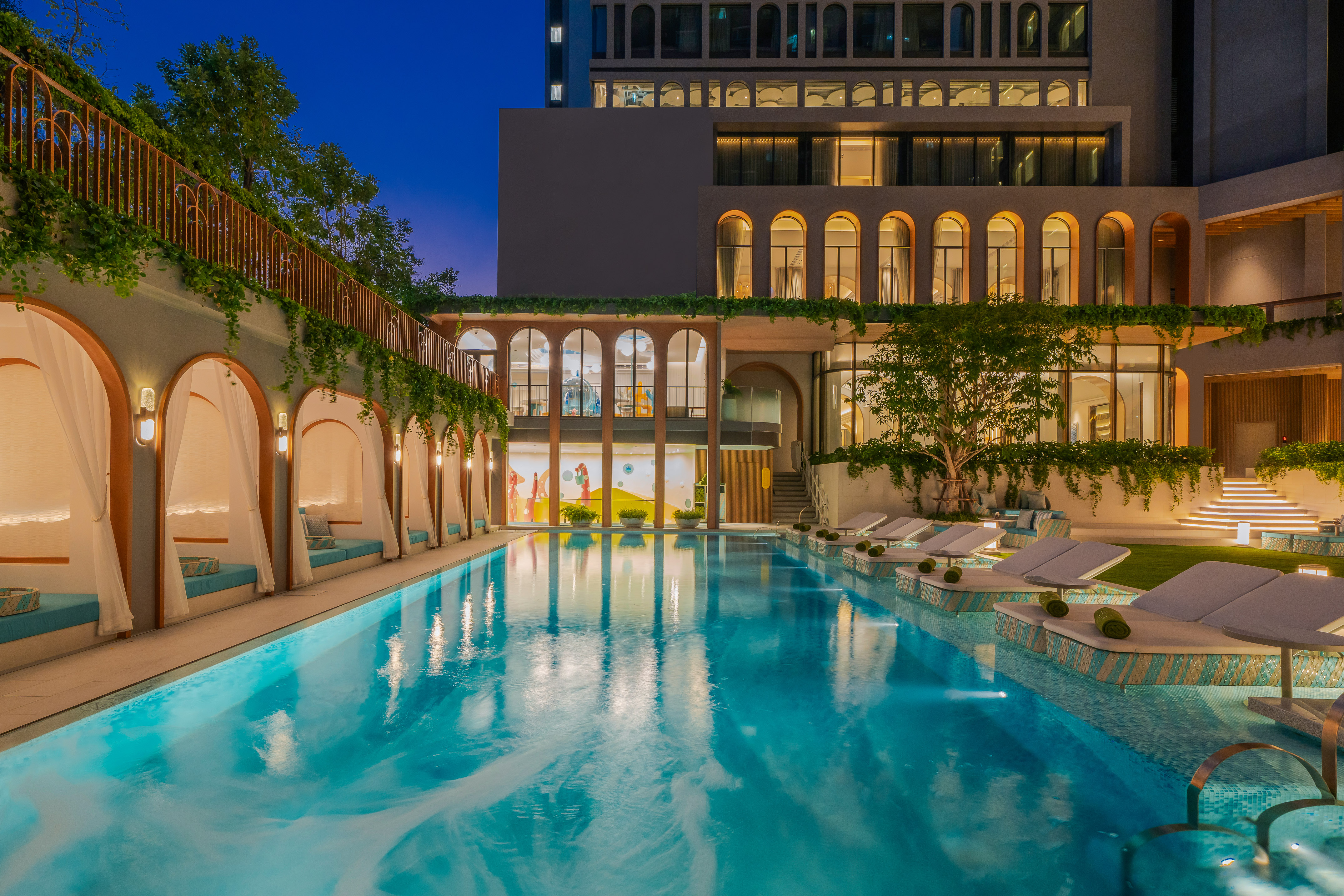 Luxury resort pool at night with cabanas, loungers, and modern architecture. - Một khoảnh khắc sảng khoái - Meliá Pattaya Hotel, Pattaya