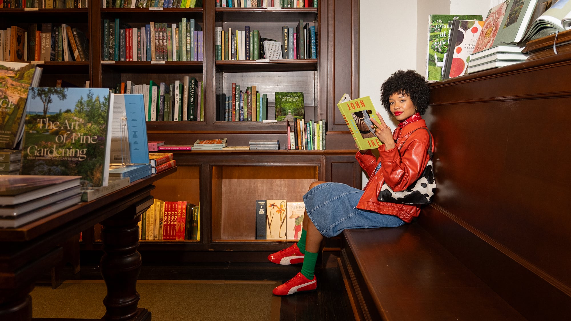 a woman sitting on a bench reading a book