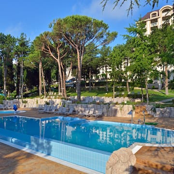 a pool with chairs and trees in the background