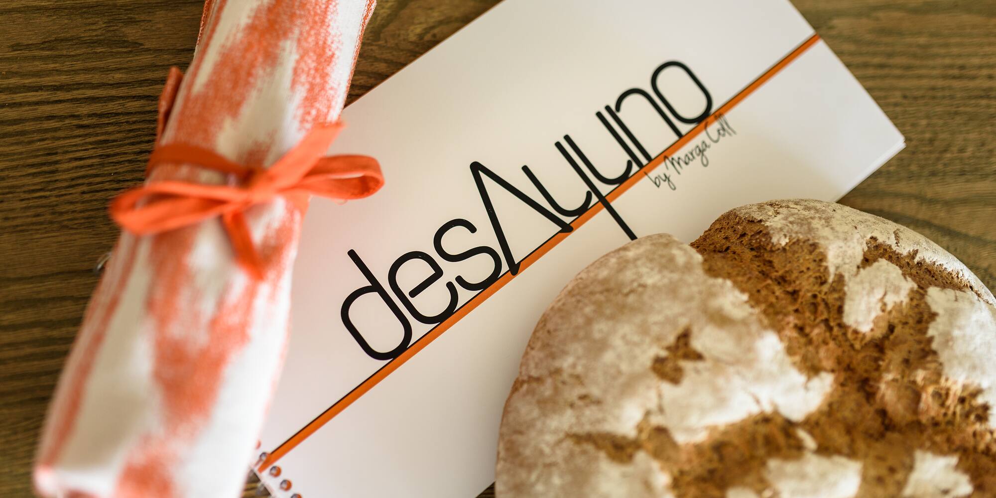 a roll of bread and a notepad on a table