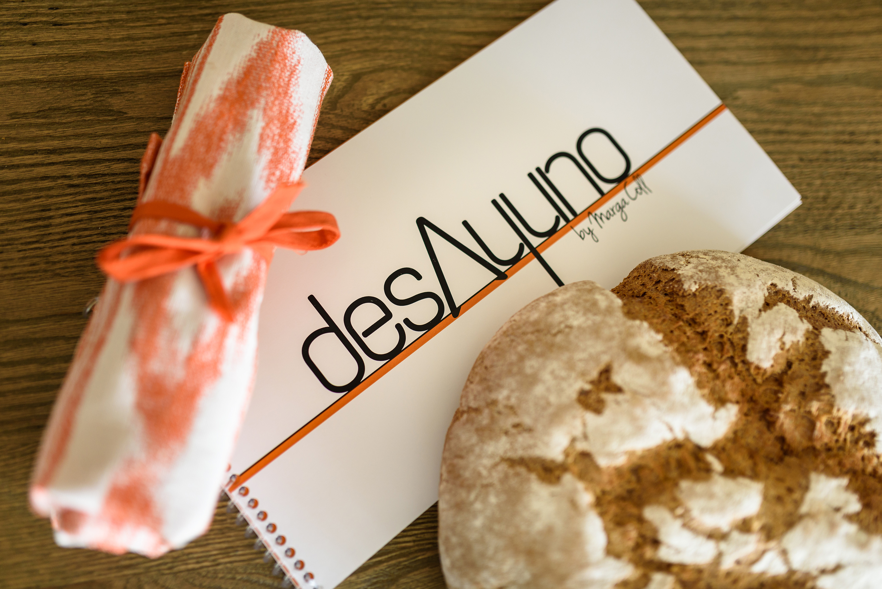 a roll of bread and a notepad on a table