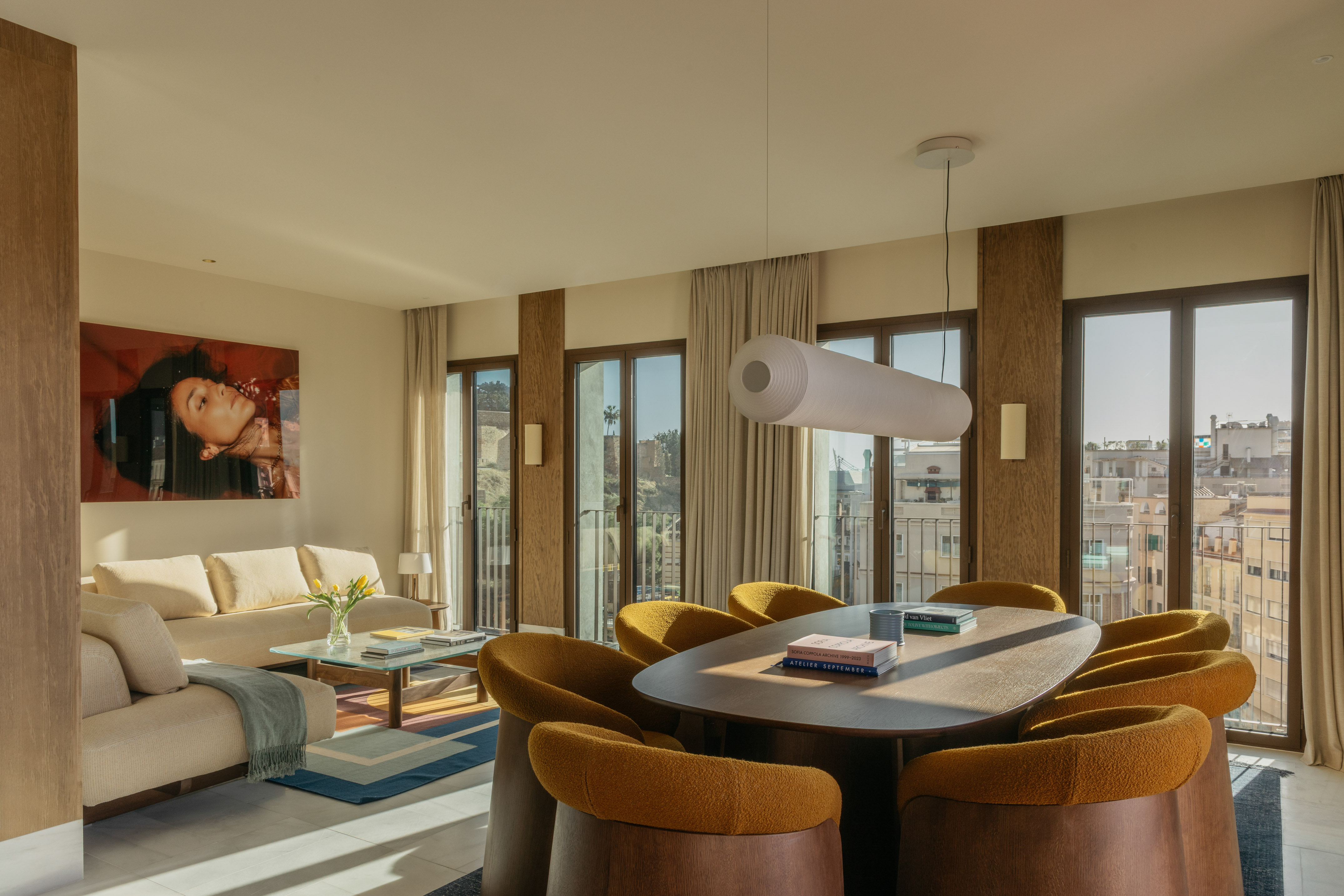 Contemporary living and dining room with mustard chairs, city view.
