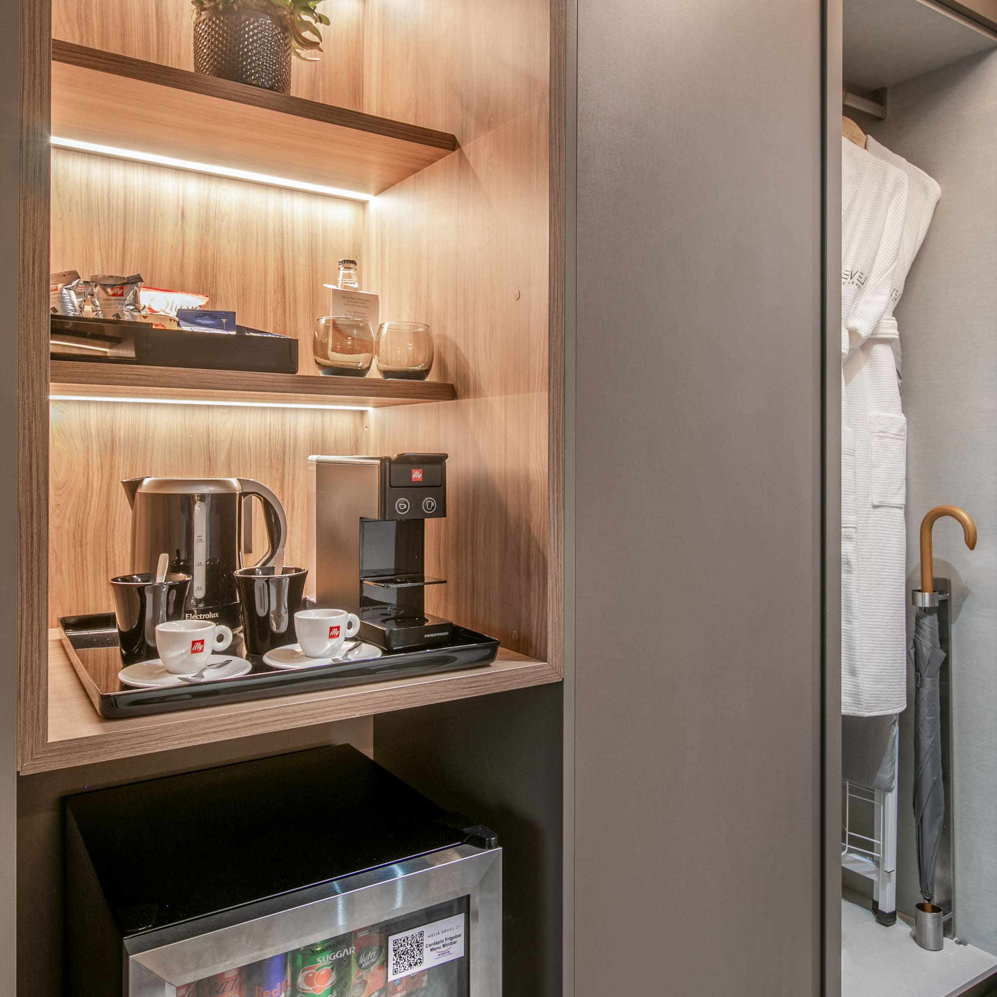 Hotel room minibar, coffee station, espresso machine, kettle, snacks, and robes.