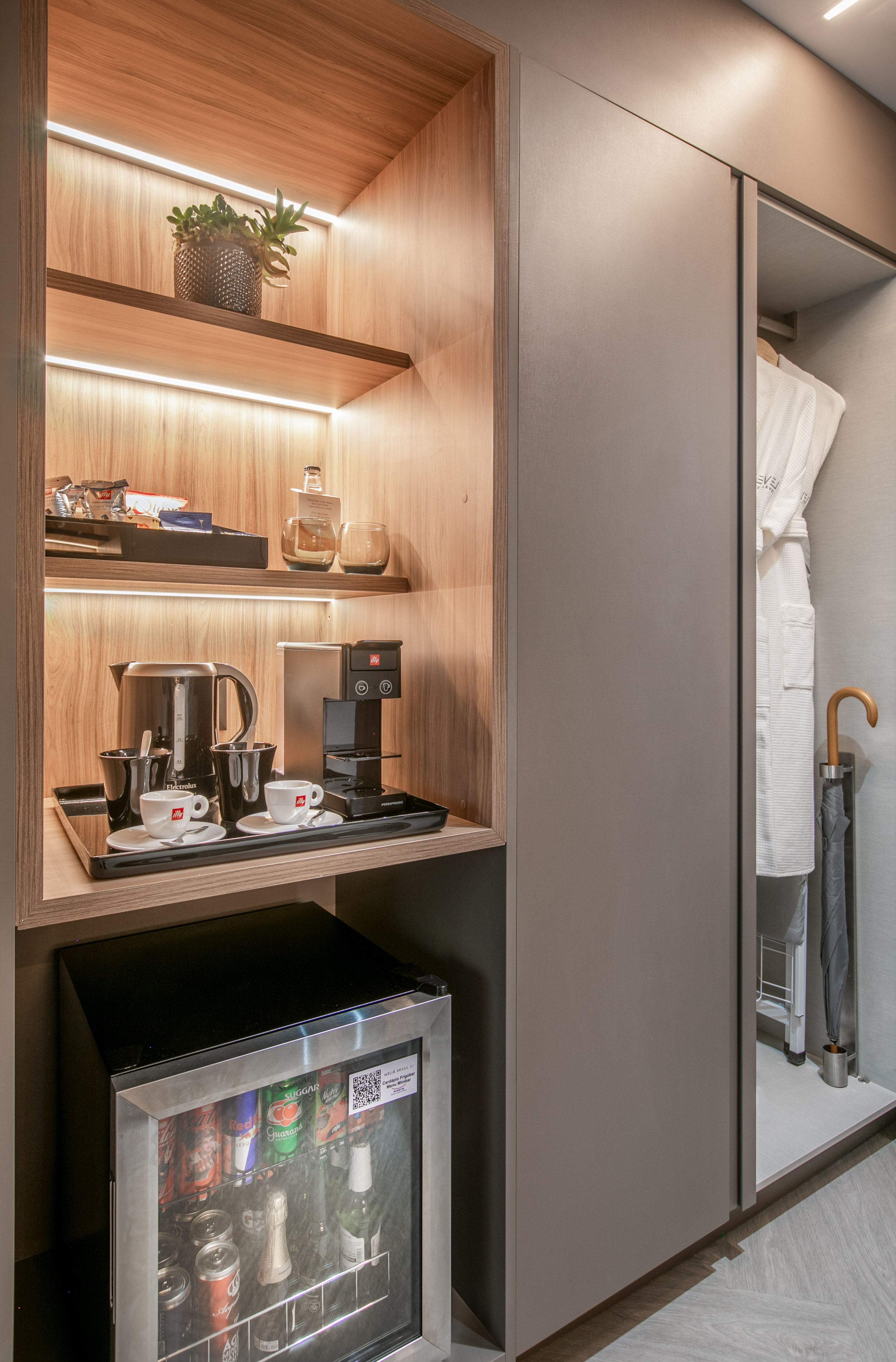 Hotel room minibar, coffee station, espresso machine, kettle, snacks, and robes.