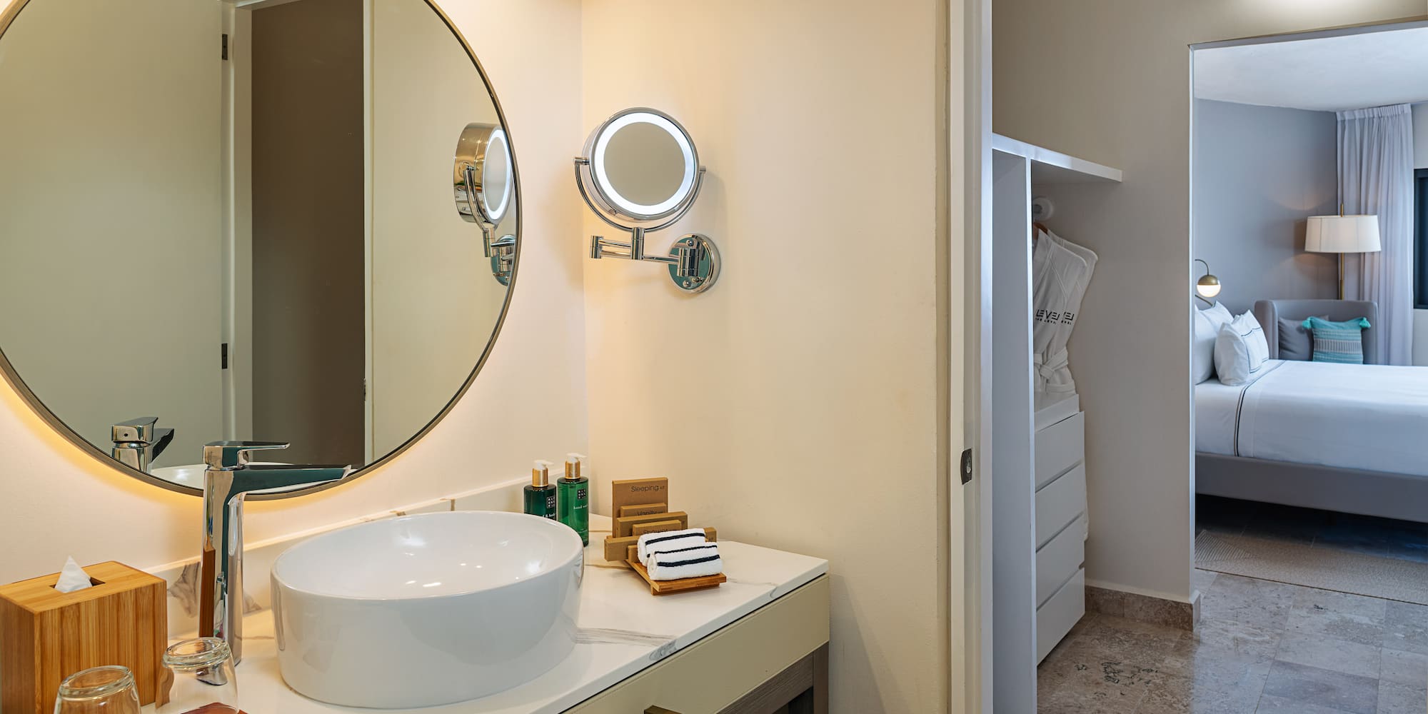 a bathroom with a round mirror and a sink