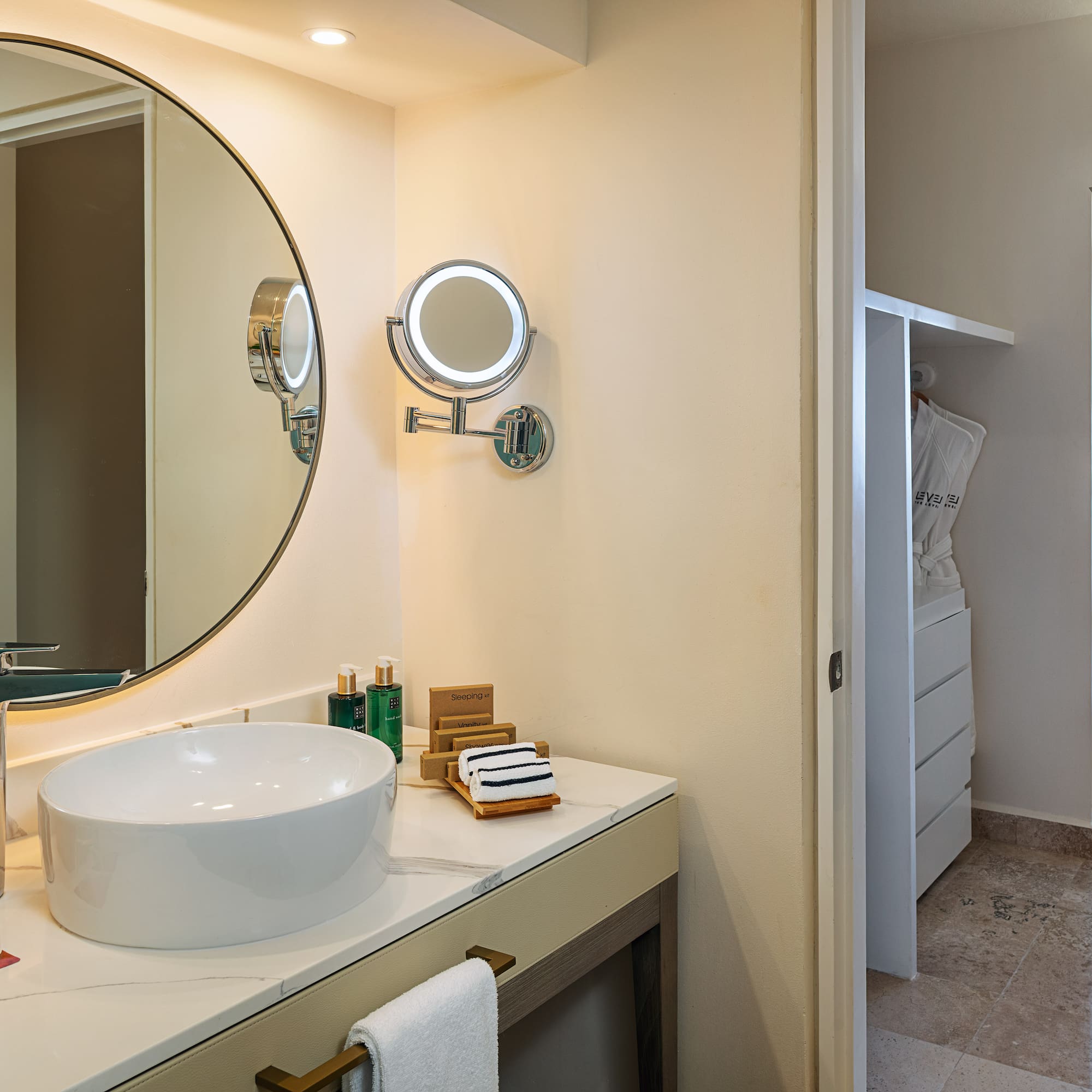 a bathroom with a round mirror and a sink