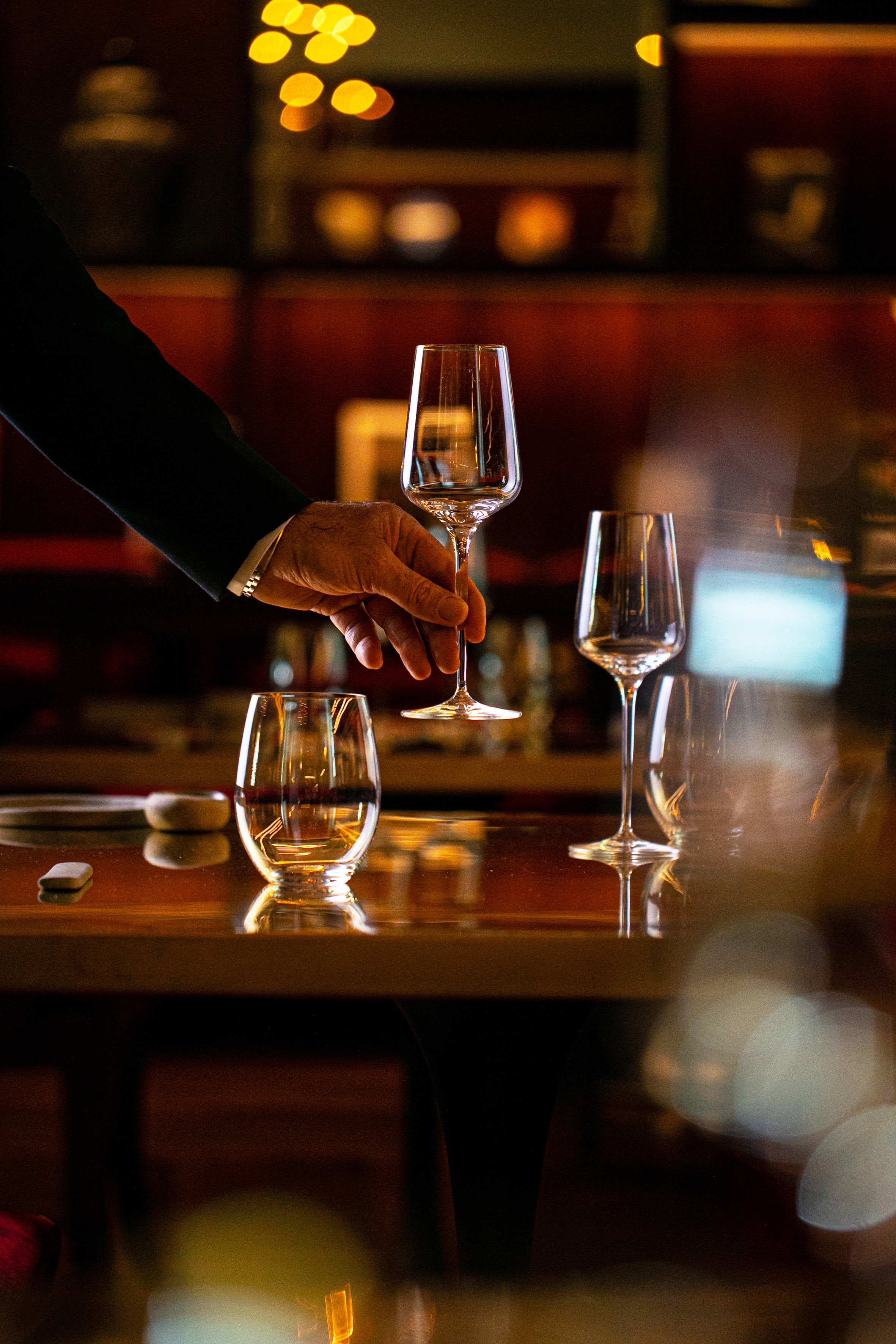 a hand holding a wine glass over a table