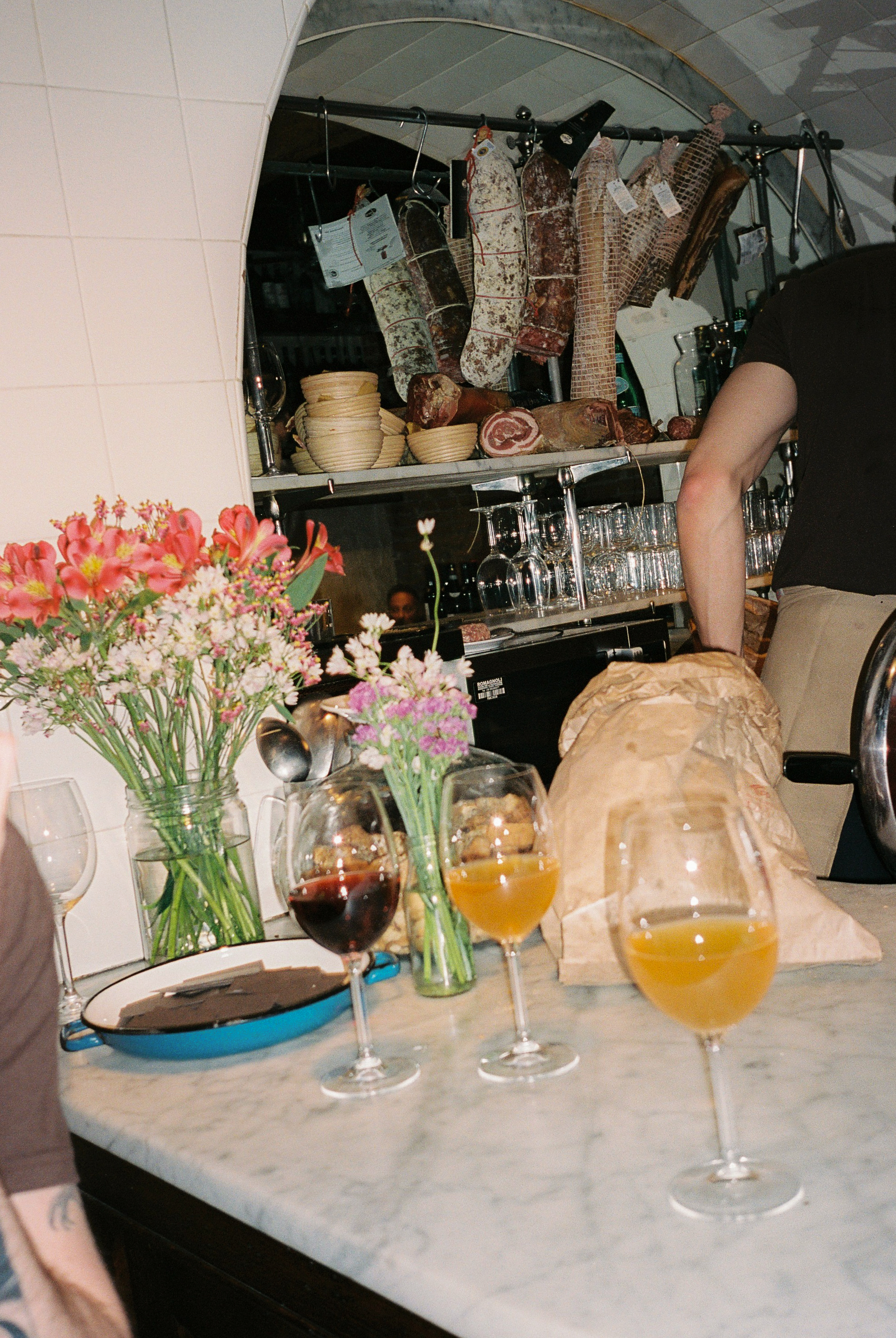 a man standing at a table with wine glasses and flowers