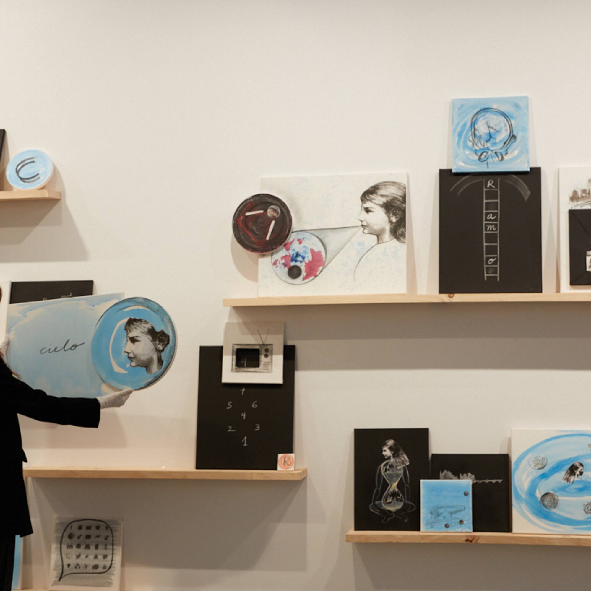 a woman standing in front of a wall with pictures