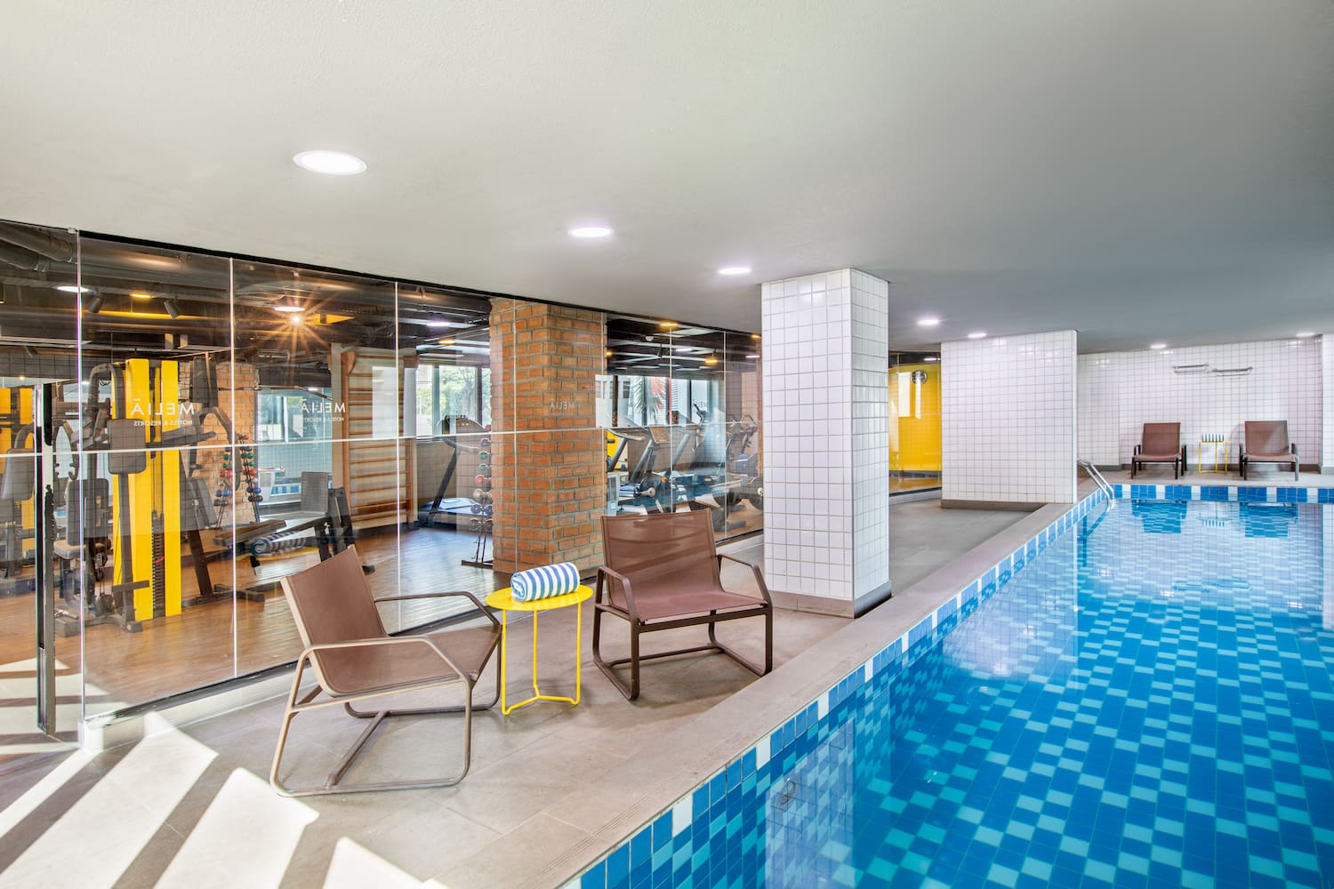 a swimming pool with chairs and a table