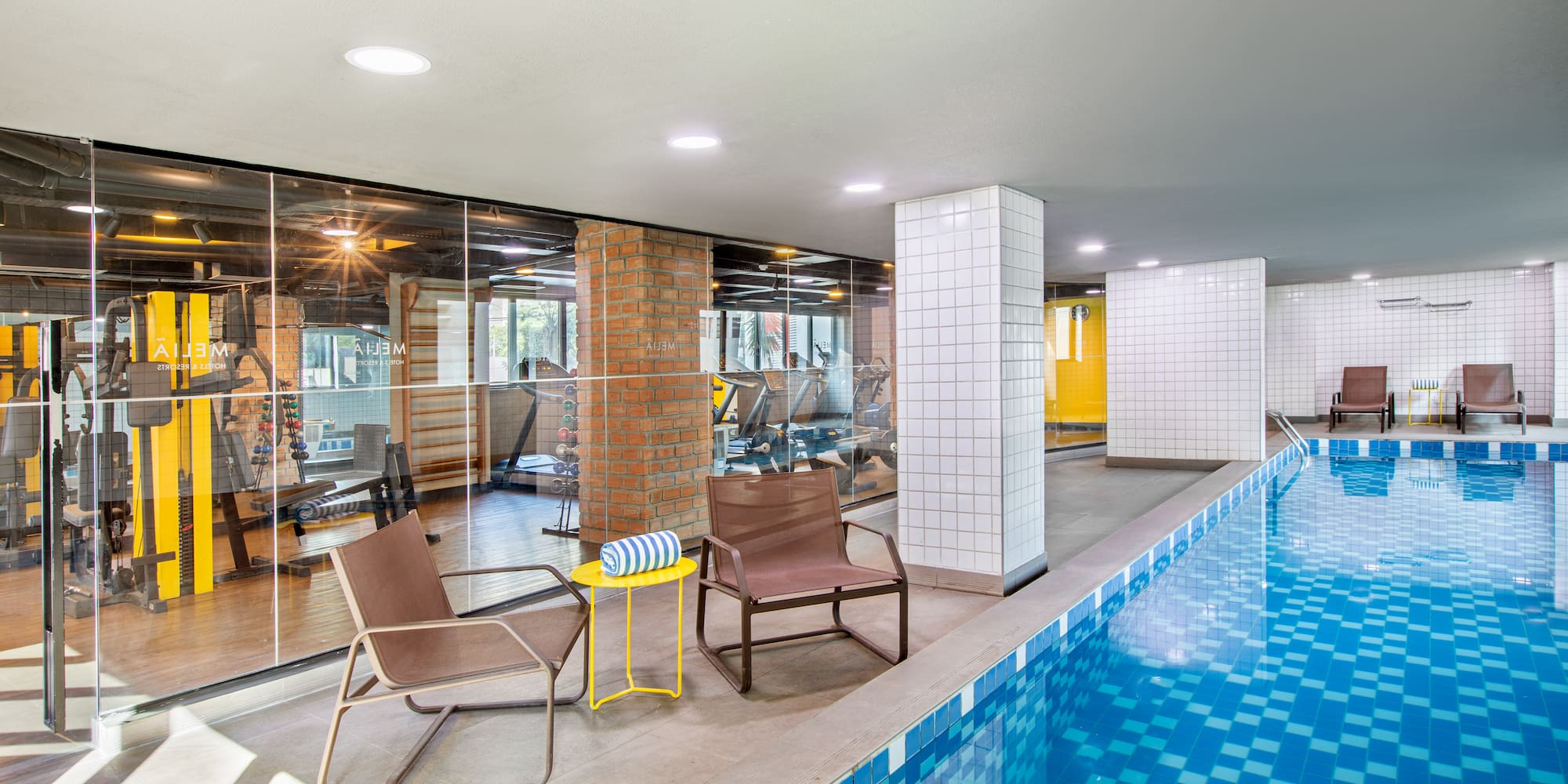 a swimming pool with chairs and a table