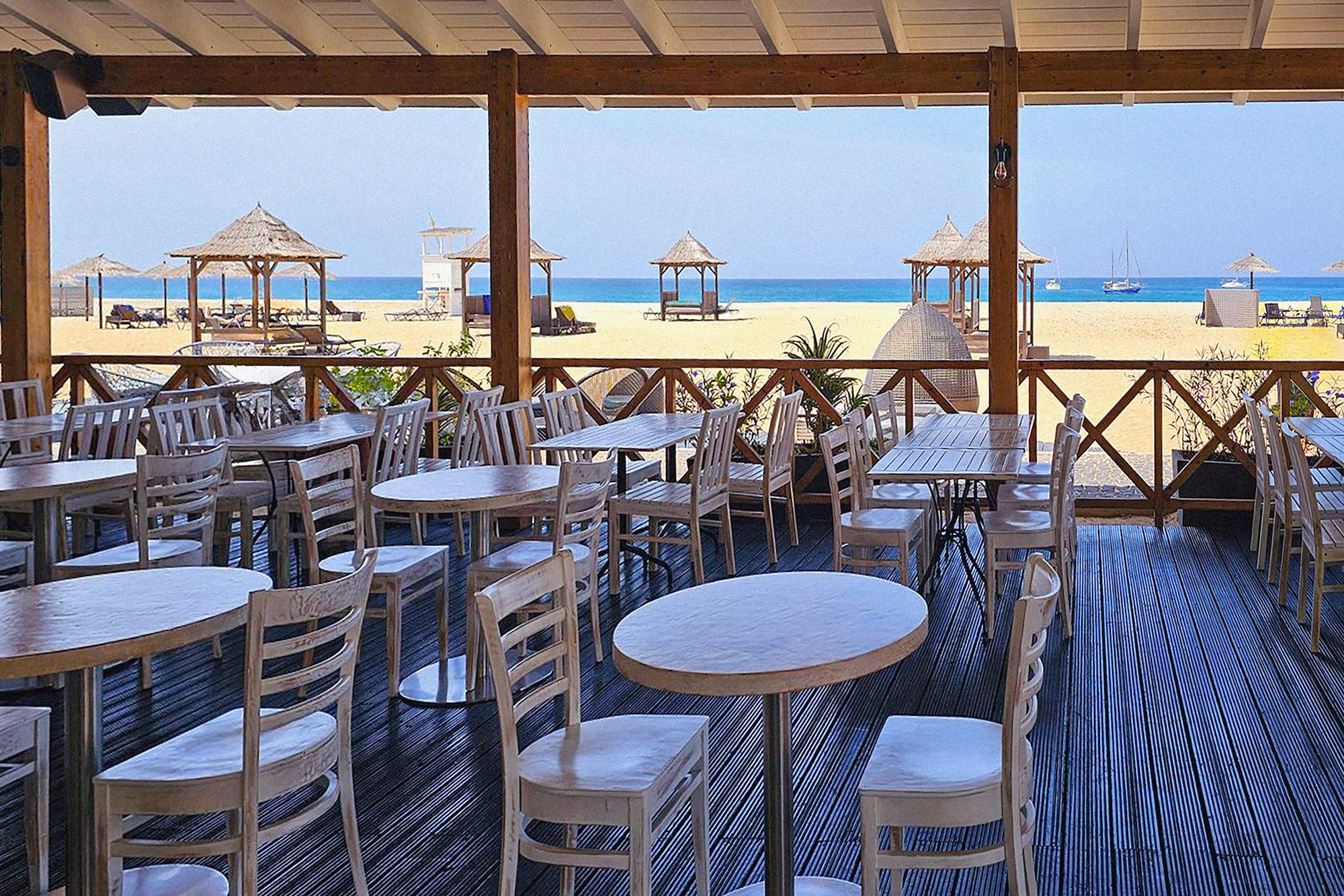 a restaurant with tables and chairs on a deck