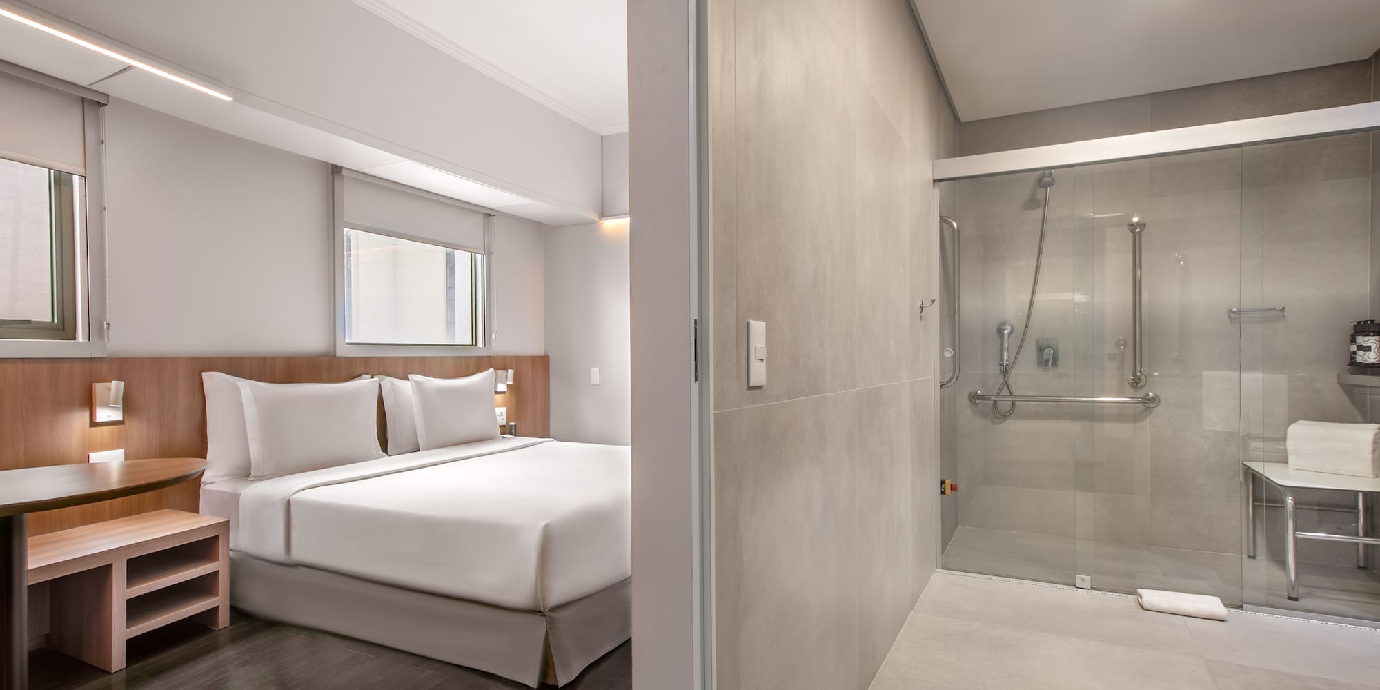 a bedroom with a glass shower and a bed