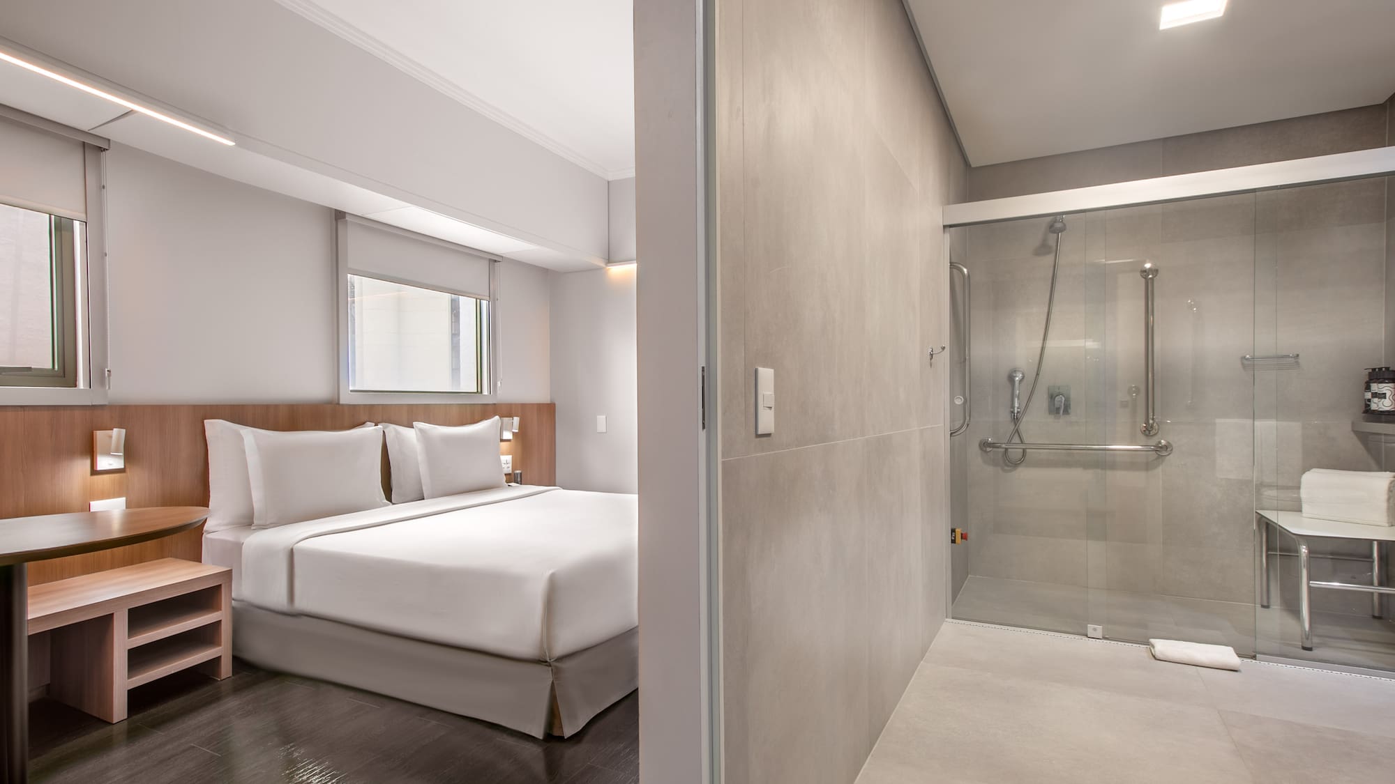 a bedroom with a glass shower and a bed