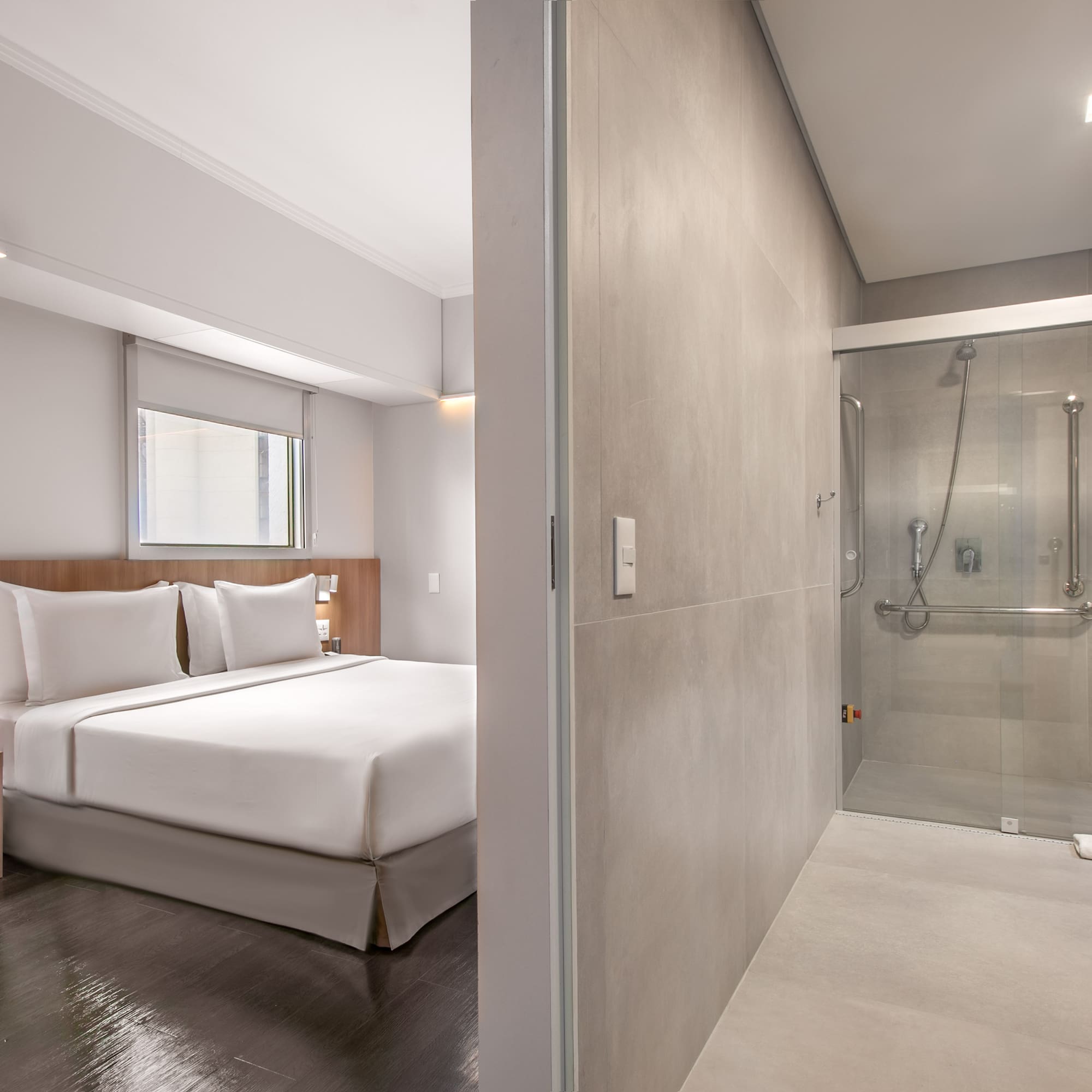 a bedroom with a glass shower and a bed
