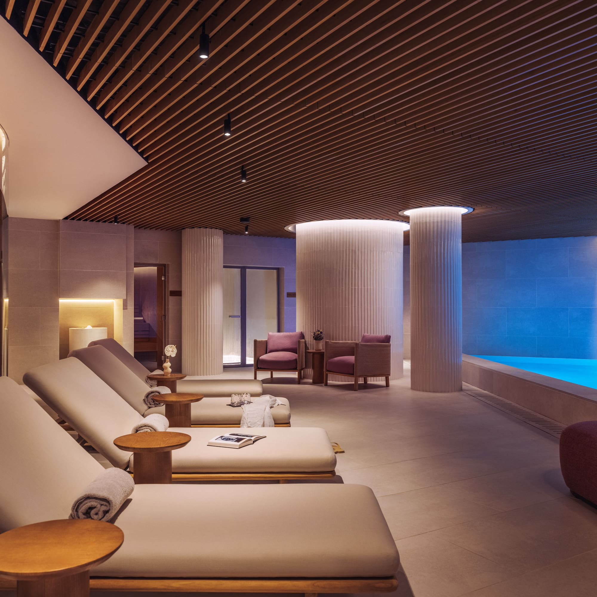 a room with chairs and a pool