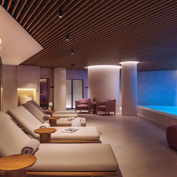 a room with chairs and a pool