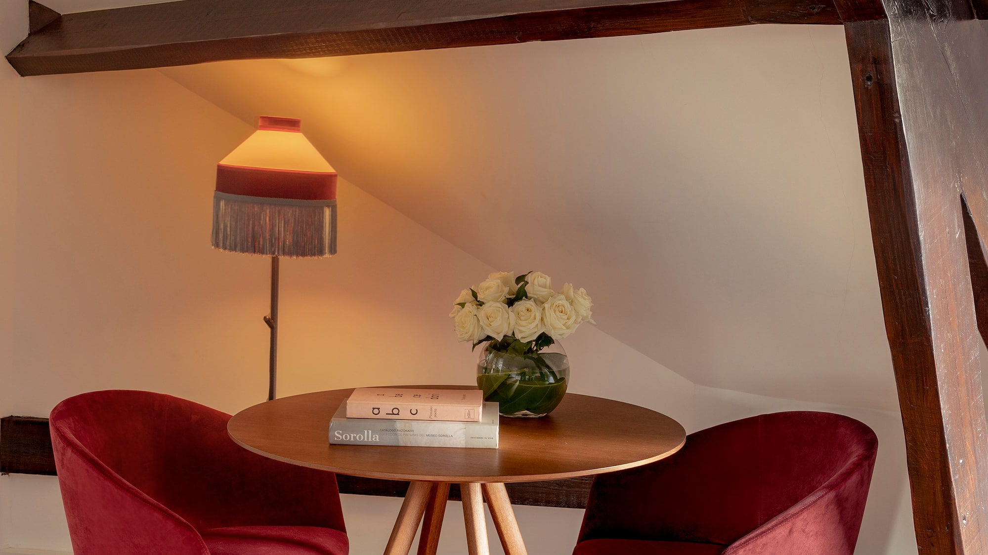 a table with red chairs and a lamp