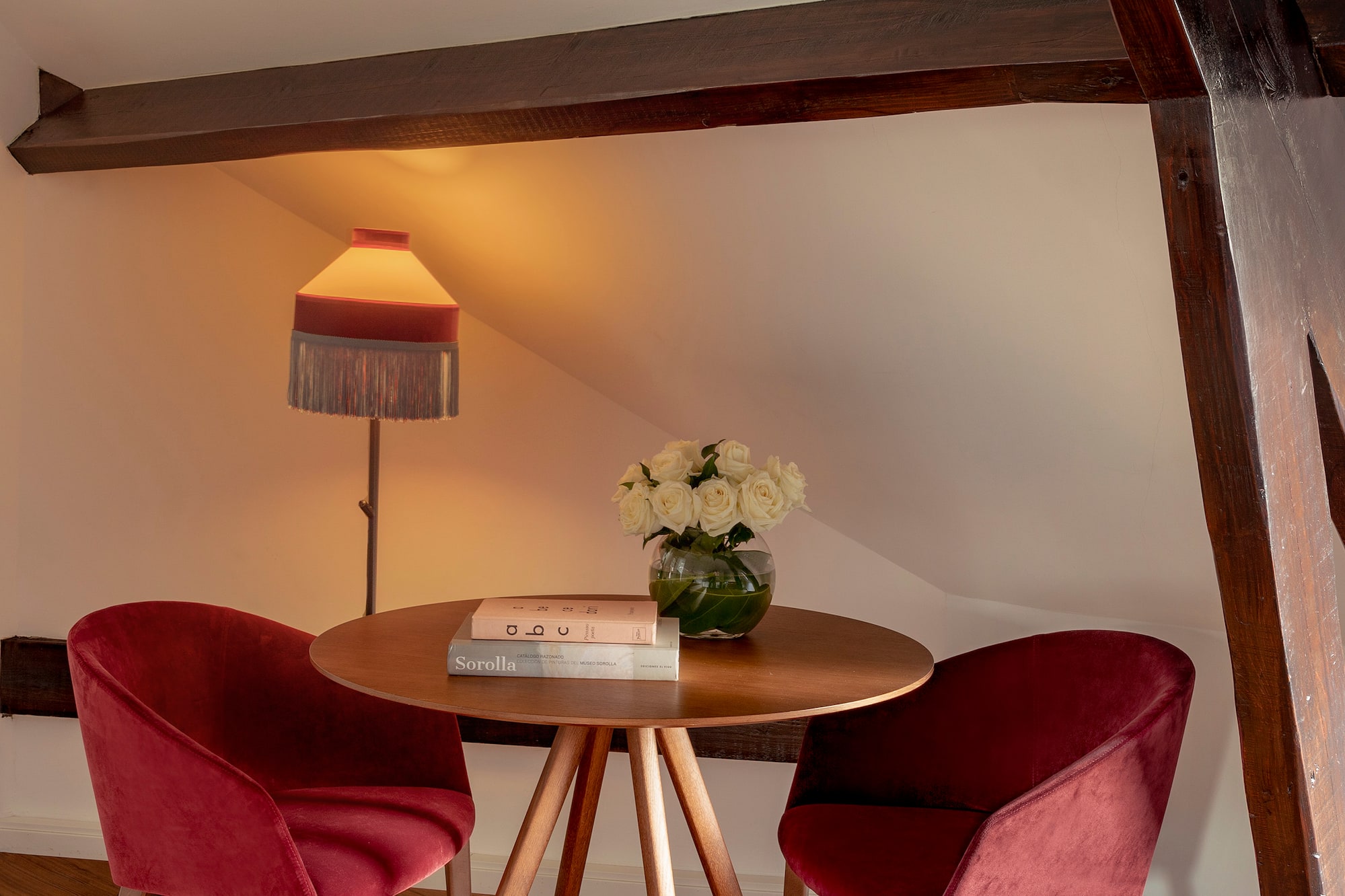 a table with red chairs and a lamp