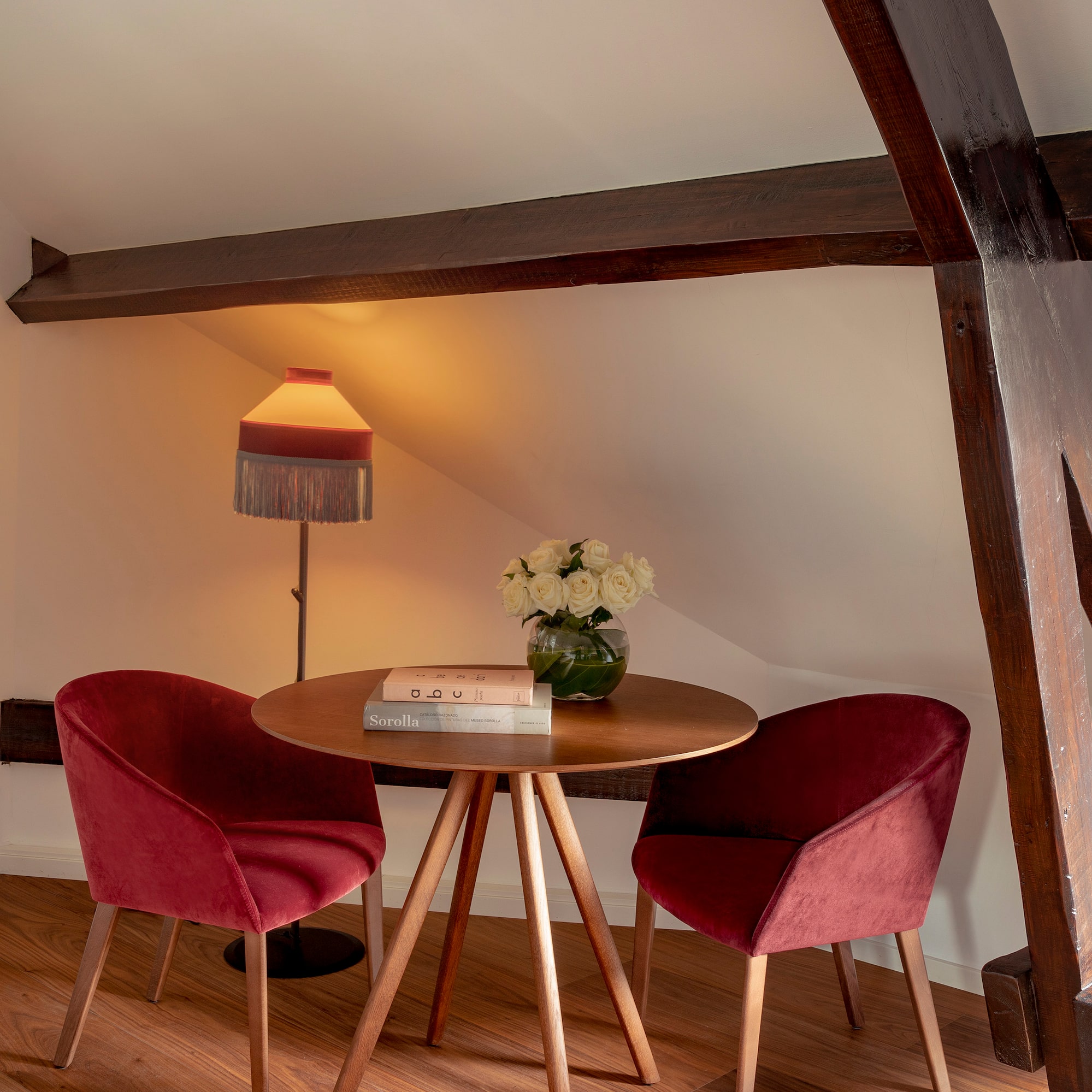 a table with red chairs and a lamp