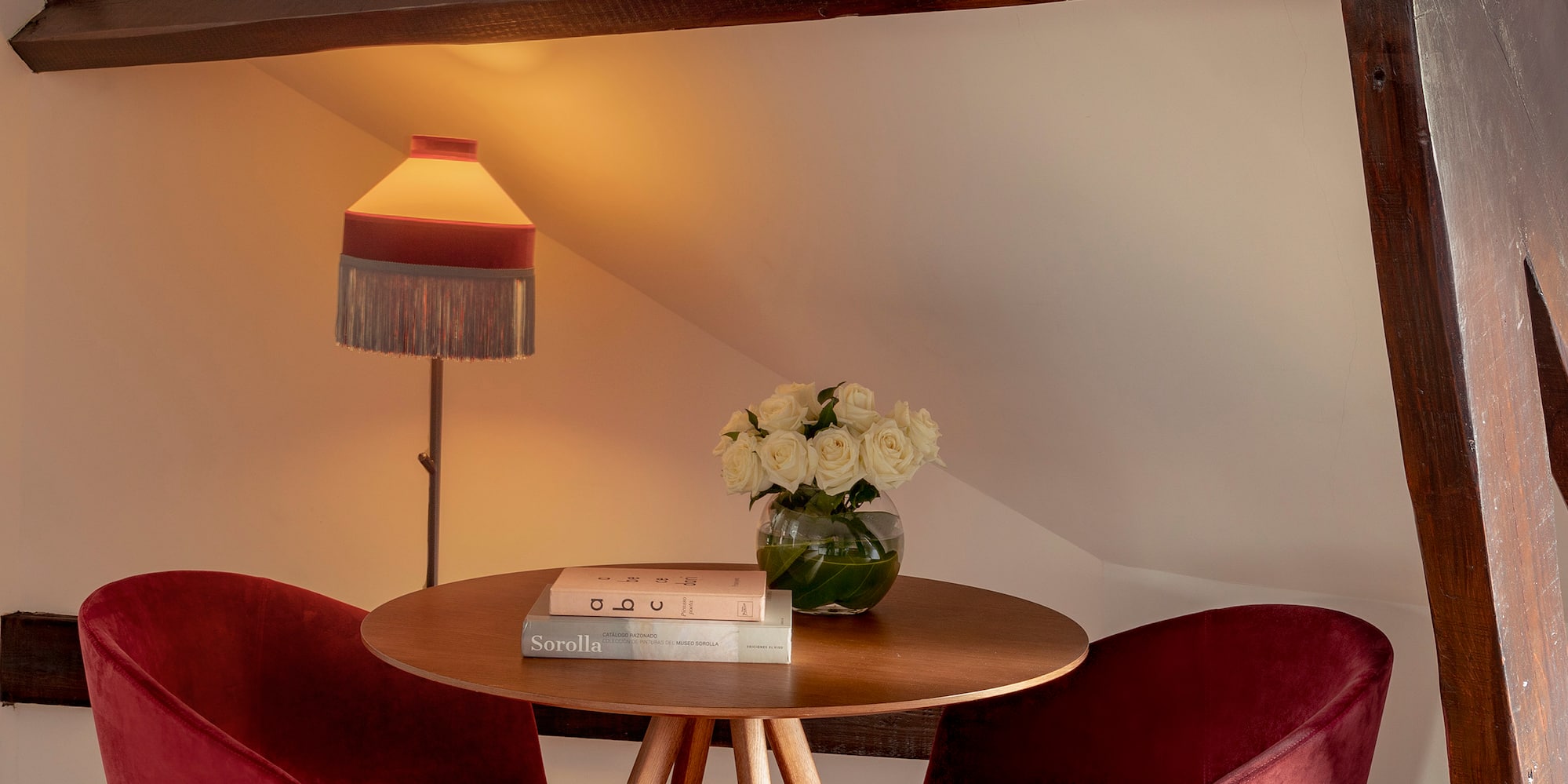 a table with red chairs and a lamp
