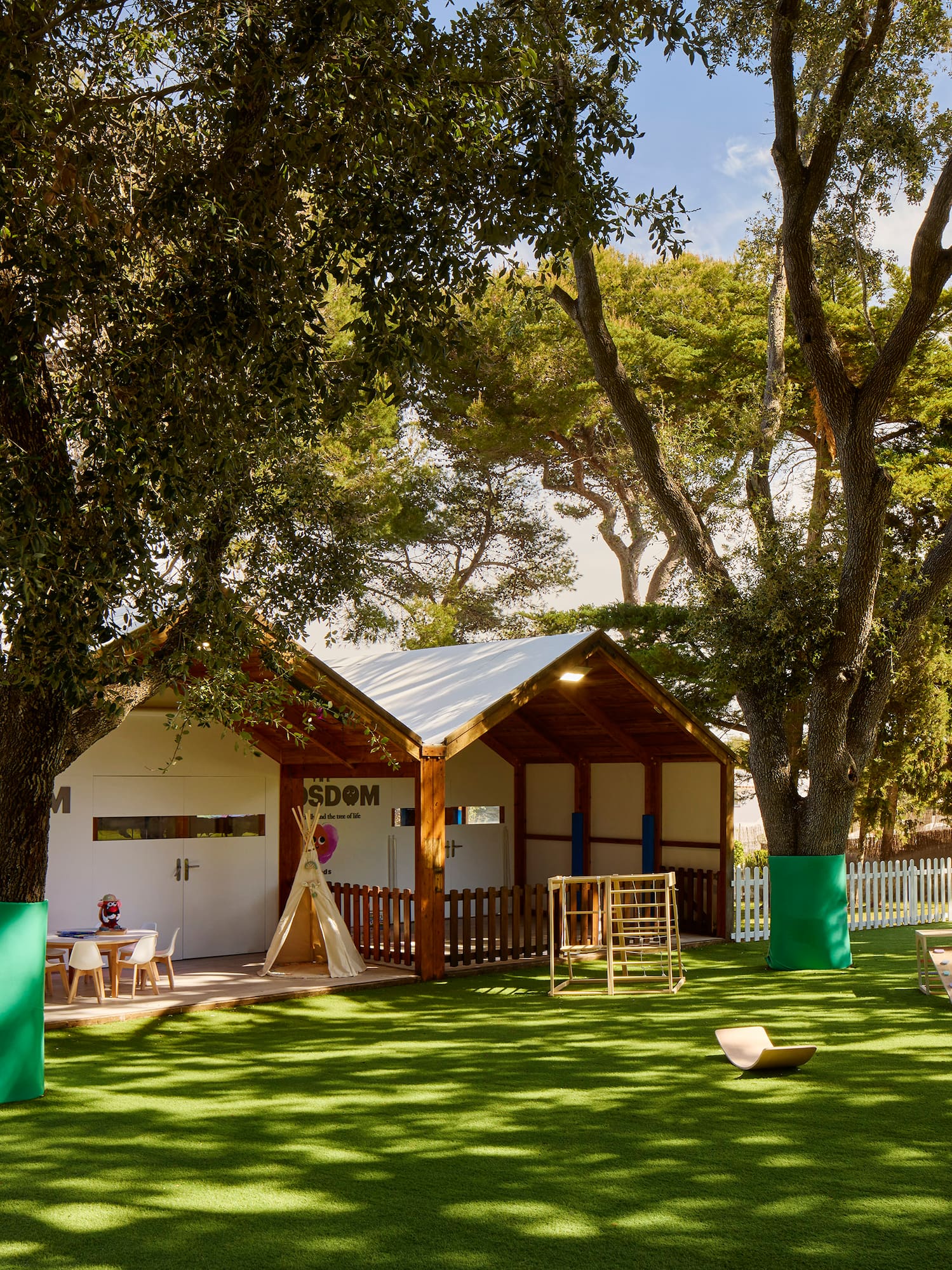 a small building with a playground in the middle of a grassy area