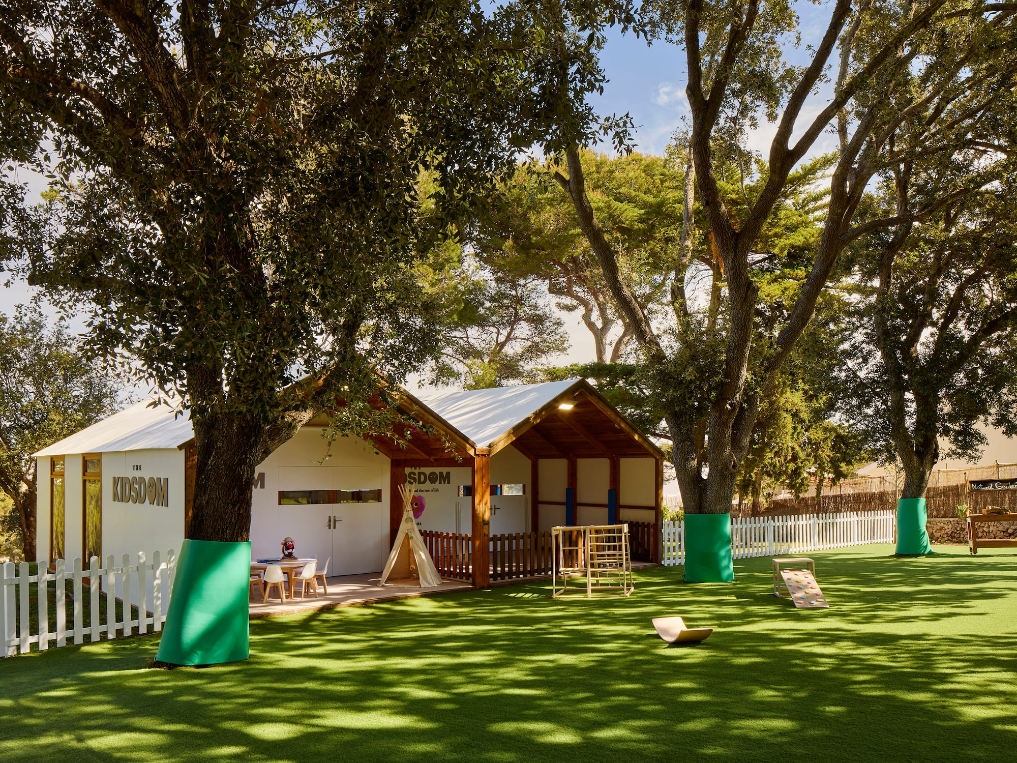 a small building with a playground in the middle of a grassy area
