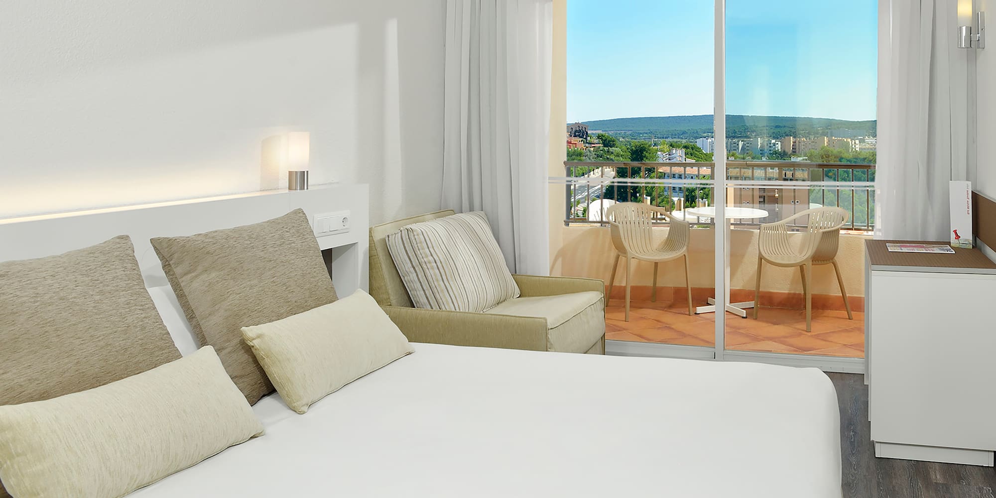 a bed with pillows and a glass door