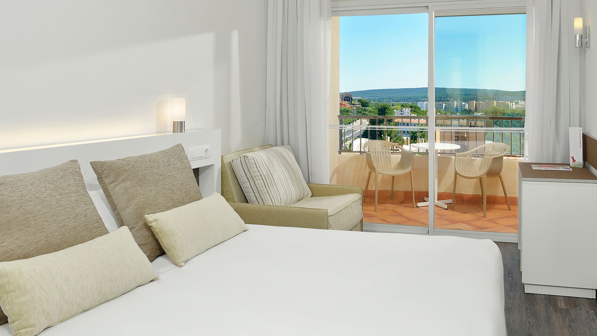 a bed with pillows and a glass door