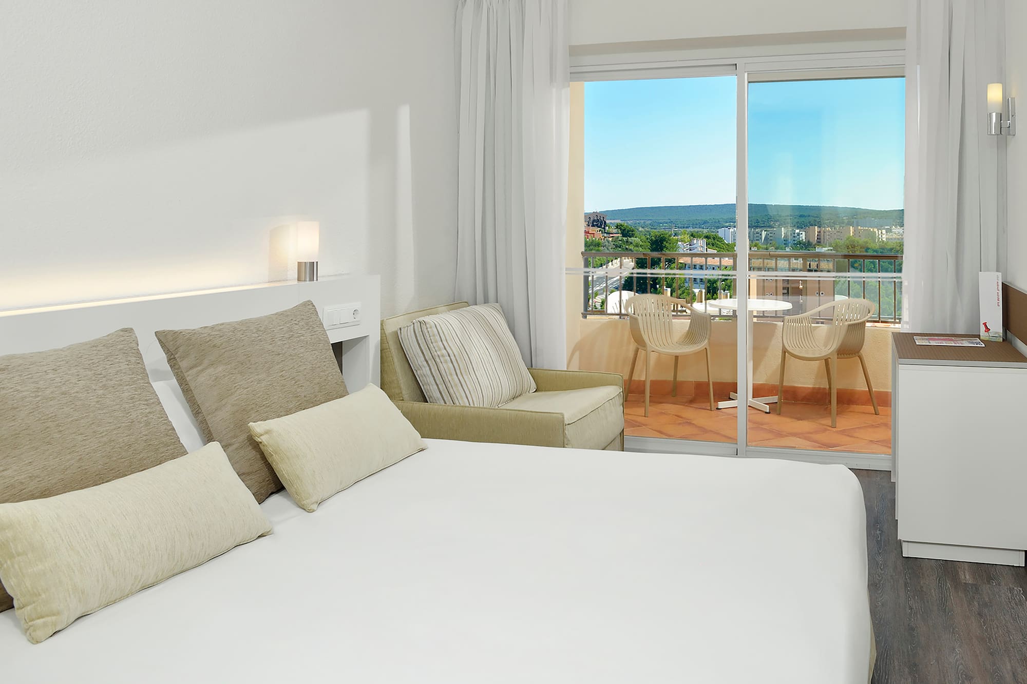 a bed with pillows and a glass door