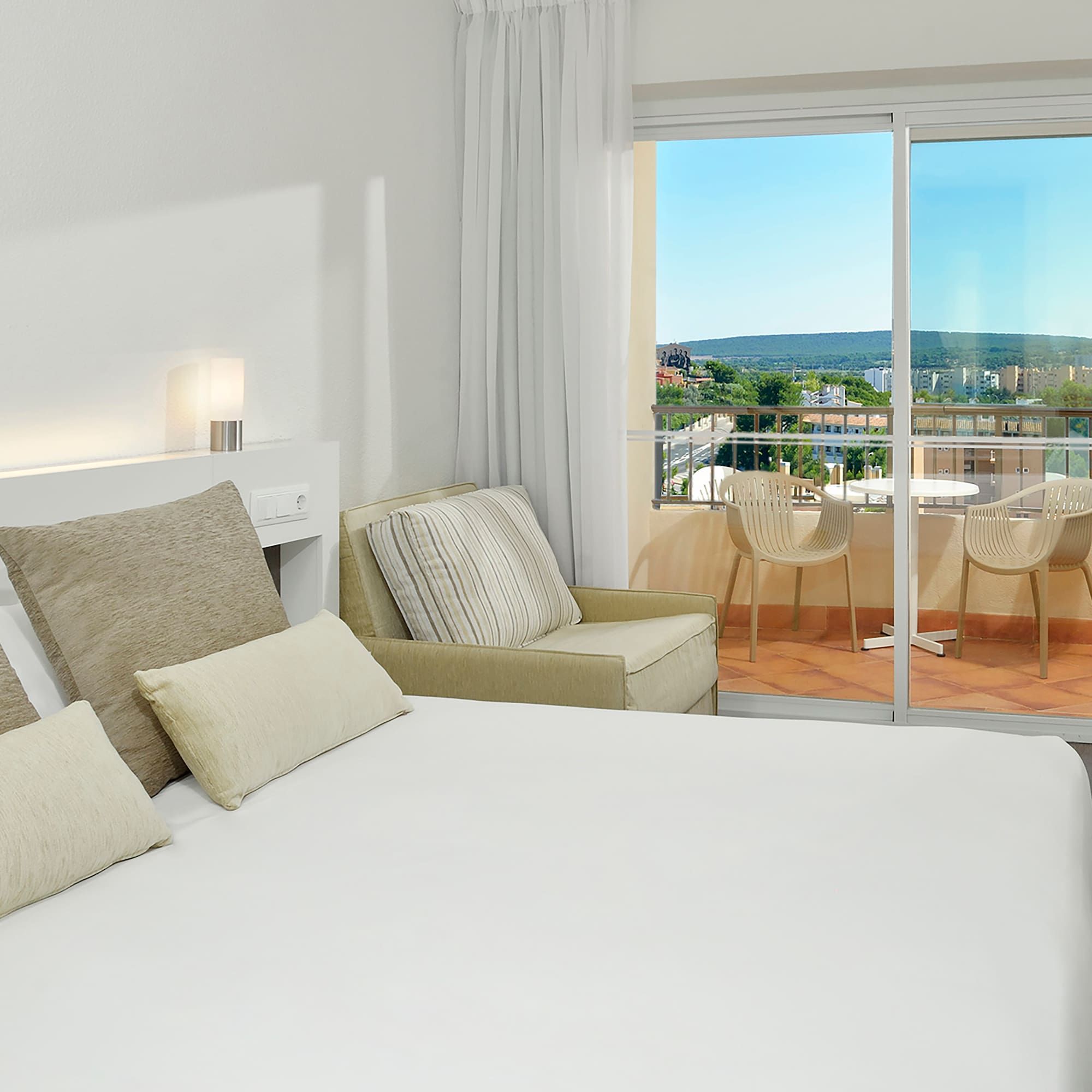 a bed with pillows and a glass door