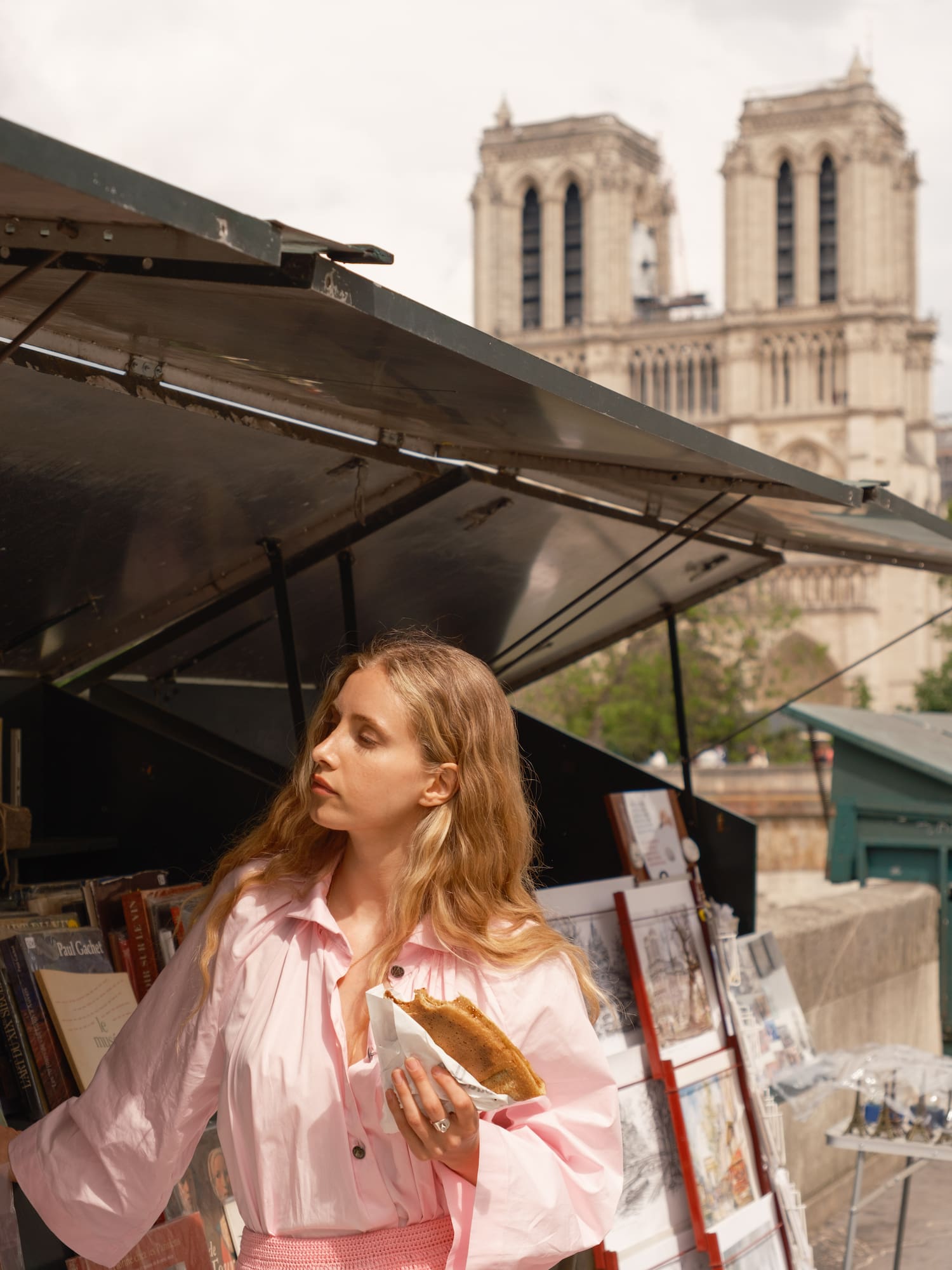 a woman standing under a tent with a sandwich
