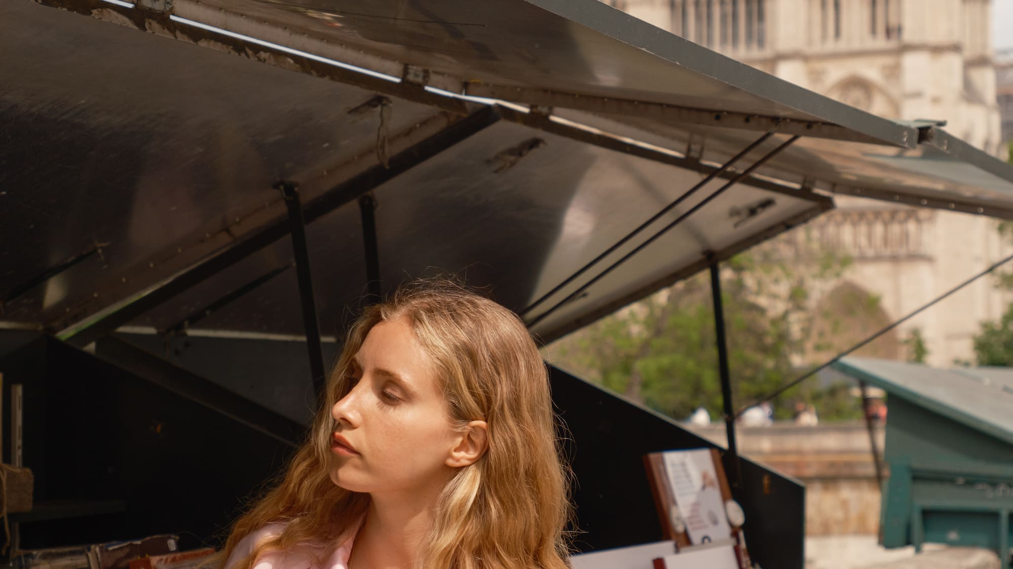 a woman standing under a tent with a sandwich