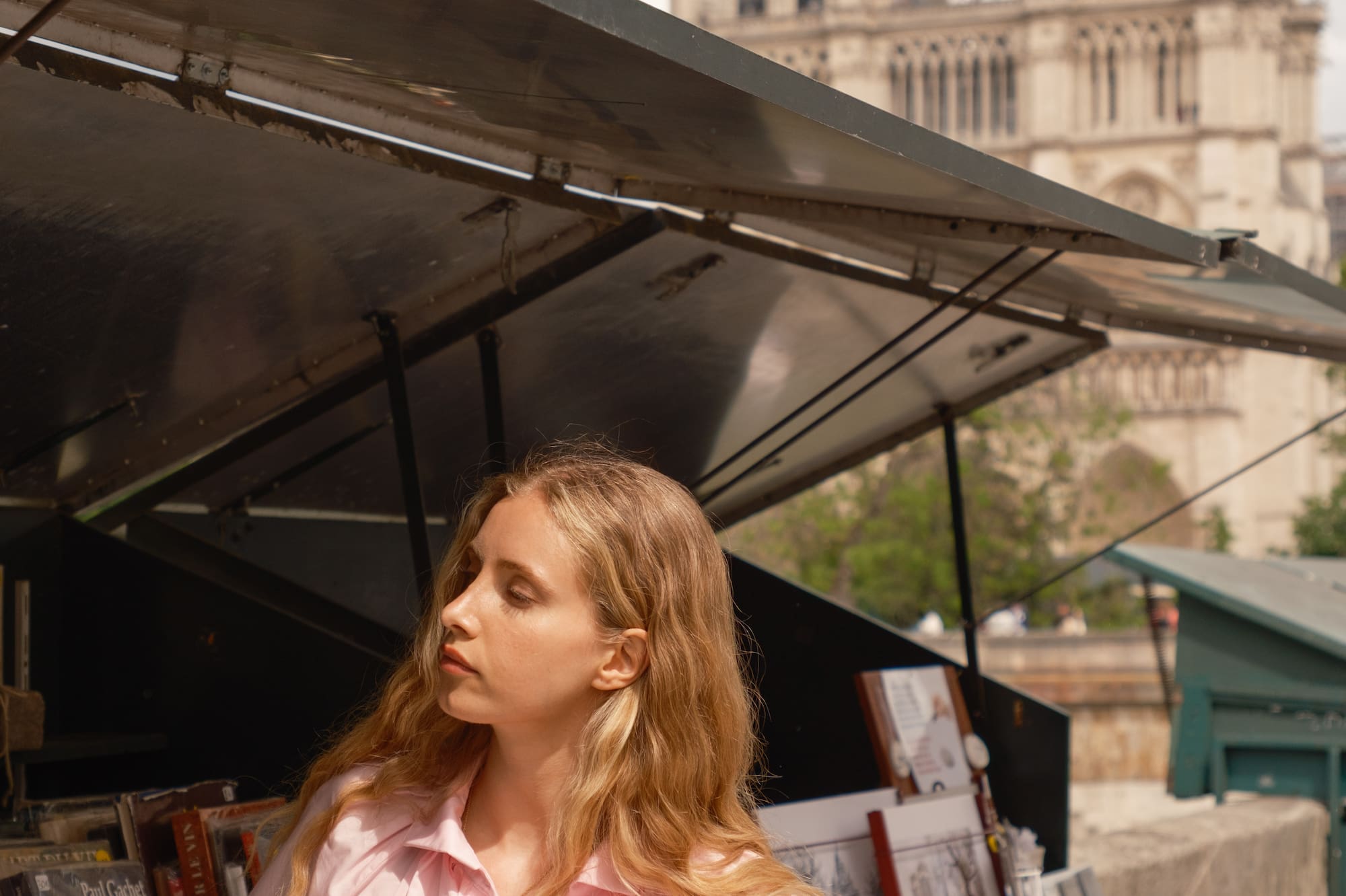 a woman standing under a tent with a sandwich